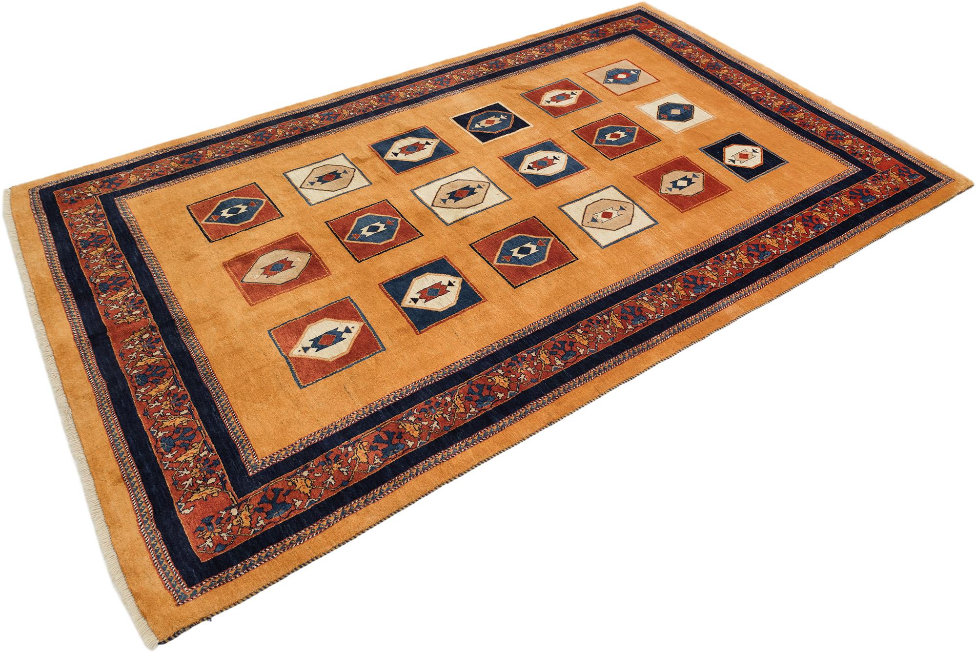 Hand-knotted Lori Gabbeh rug, woven by tribal artisans in Southwest Persia.

This piece showcases a playful geometric allover design with stylized diamond medallions arranged in rows, each featuring bold color contrasts of deep red, navy blue,