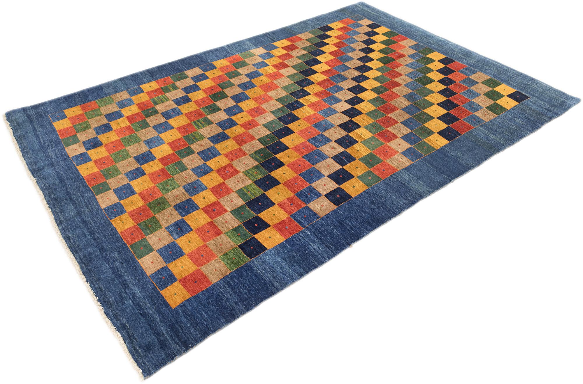 Tappeto Lori Gabbeh annodato a mano, tessuto da tessitori tribali in Iran.

Presenta un audace disegno a scacchiera nei vivaci colori del rosso, giallo, verde, blu e beige, incorniciato da un ampio bordo blu. Ogni quadrato presenta sottili