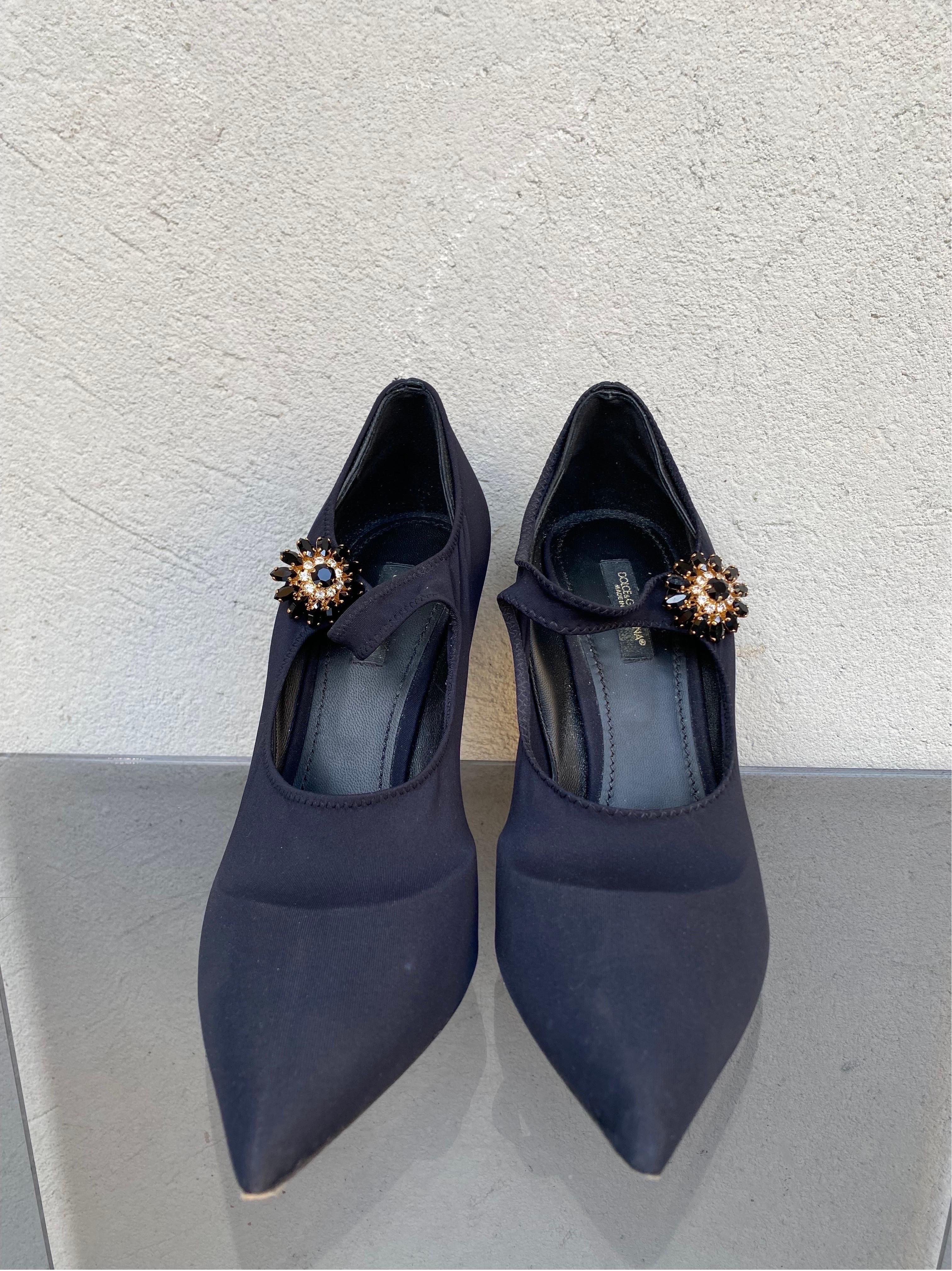 Lori Mary Janes aus Stretch-Jersey mit Schmuckknopfdetails von Dolce & Gabbana. 
Die Schuhe haben einen dünnen Absatz und sind mit Stretch-Jersey umwickelt. 
Die Ledersohle mit dem Logo auf dem Label wertet das Design zusätzlich auf. 
Nummer
