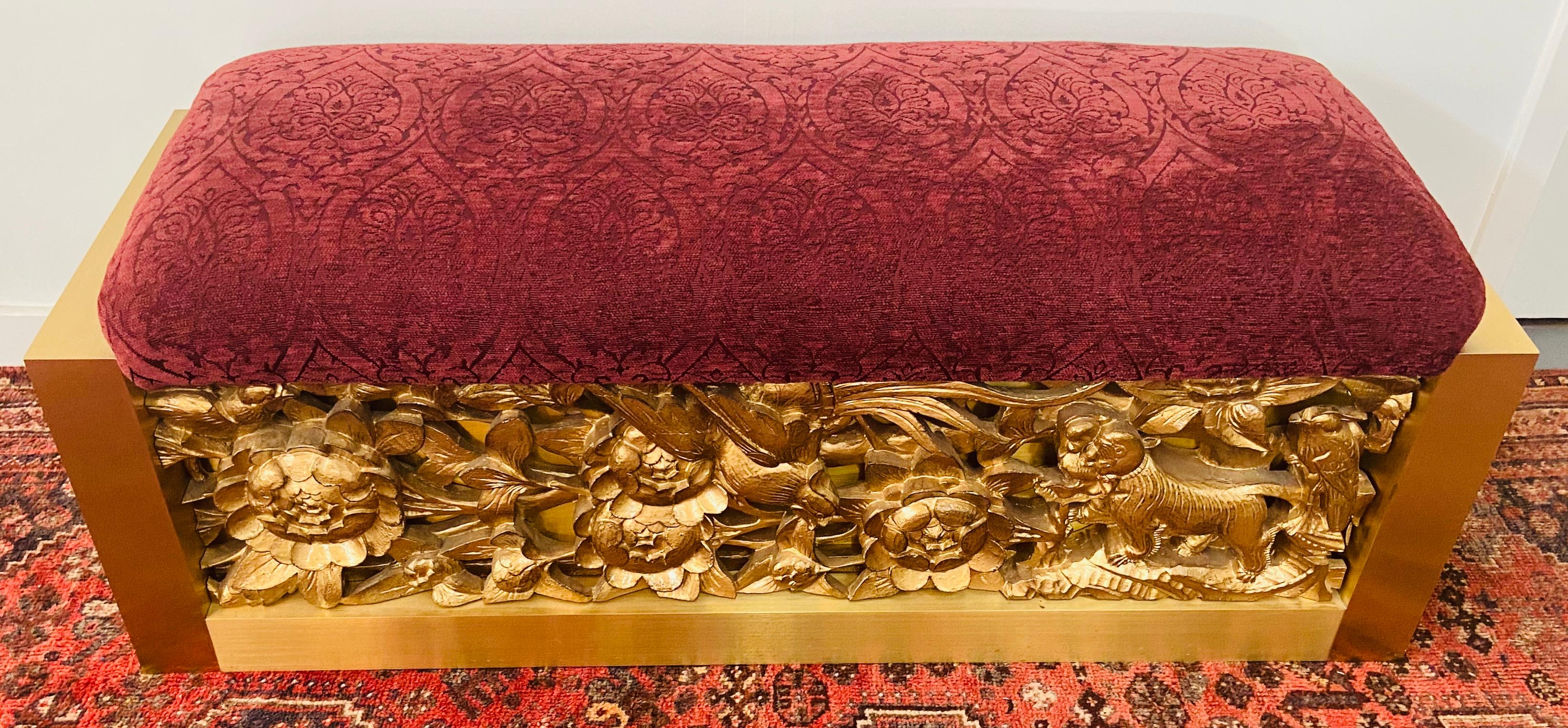 A stunning red suede top bench by Lorin Marsh. This one of a kind bench features a fine hand carved gilt wood base on both side (Front and Back). The bench sides are made of steel in an elegant beveled cut. The carving shows flowers, leafs, birds
