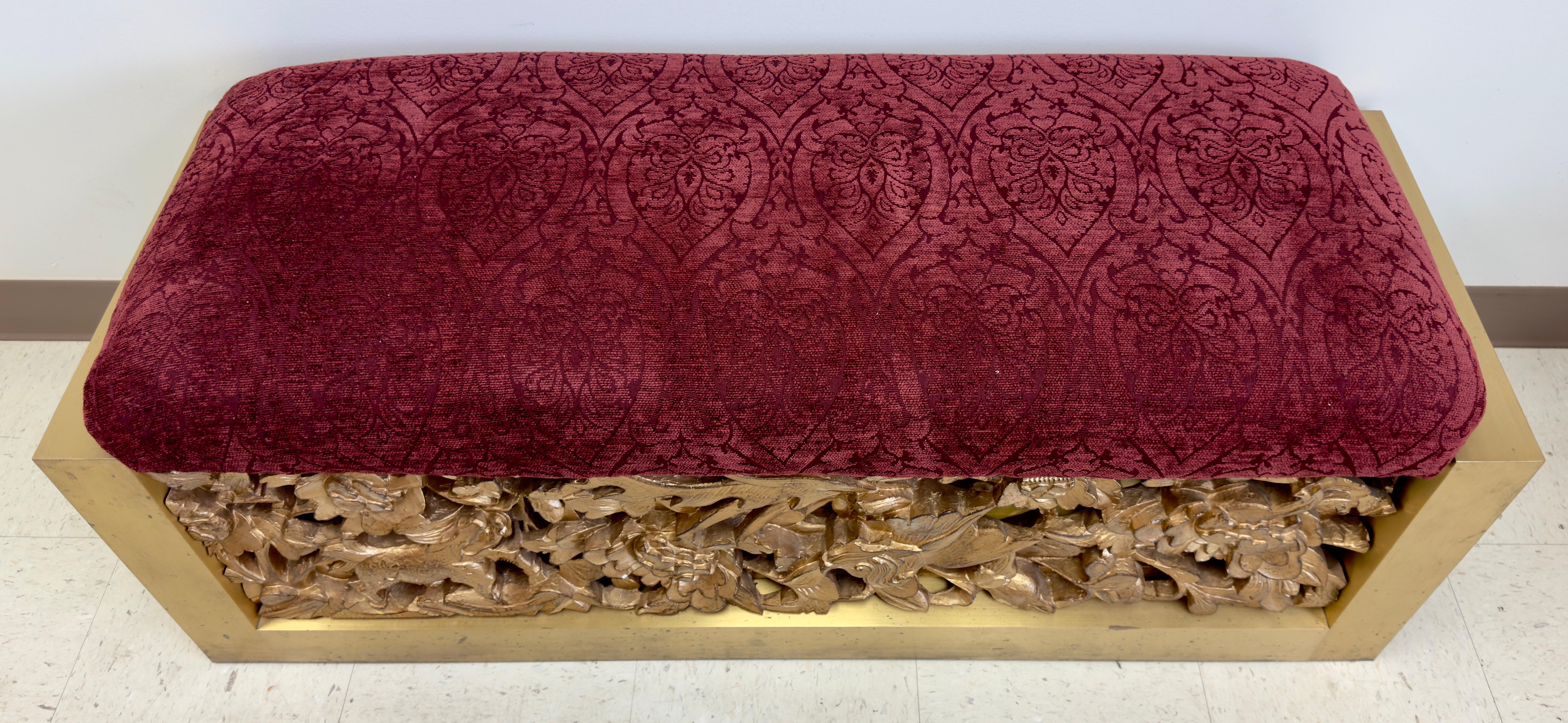 A stunning red suede top bench by Lorin Marsh. This one of a kind bench features a fine hand carved gilt wood base on both side (Front and Back). The bench sides are made of steel in an elegant beveled cut. The carving shows flowers, leafs, birds