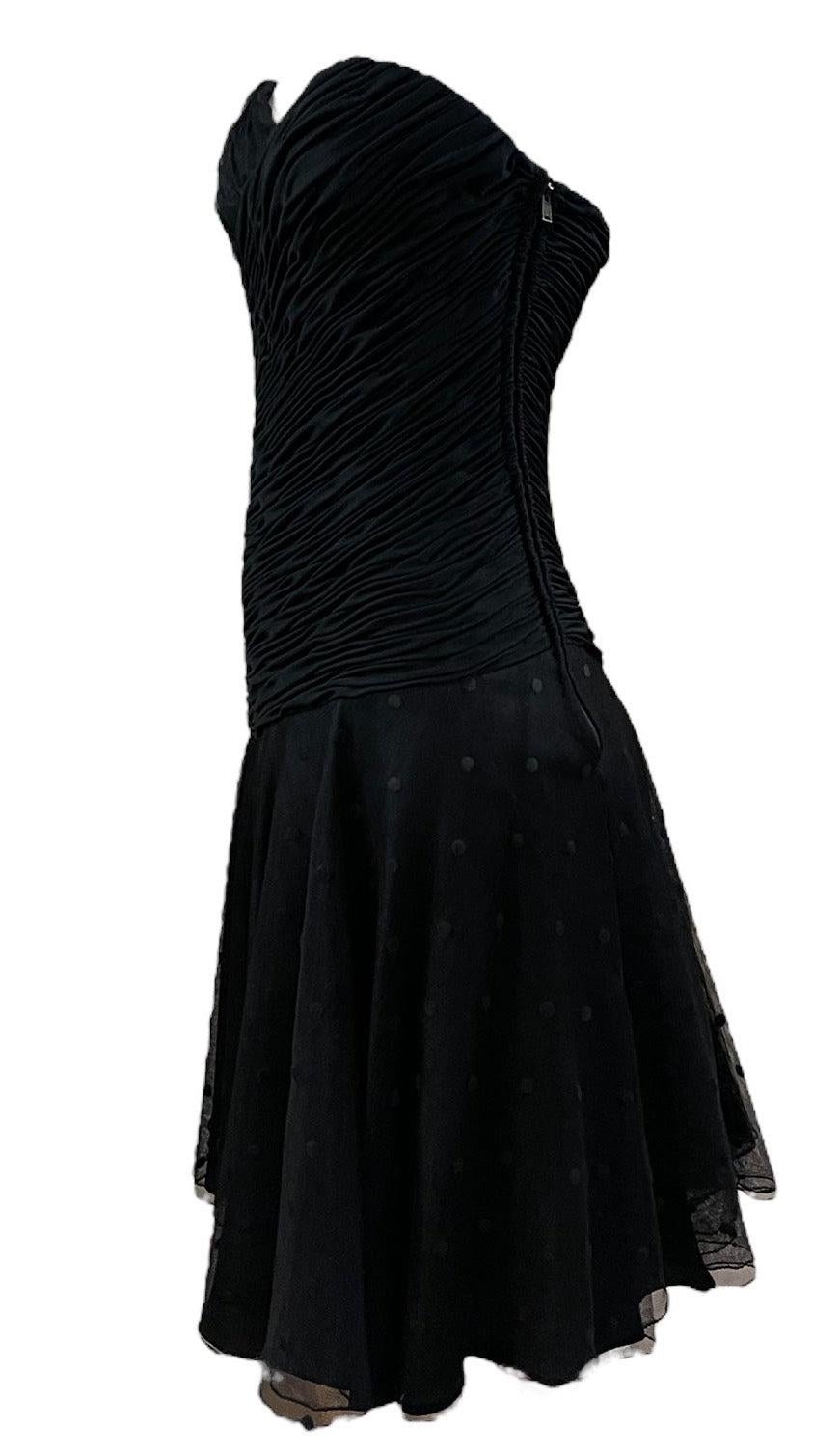 Petite robe noire abrégée, douce et sexy, de la créatrice à l'origine de nombreux looks de scène de Tina Turner.  au fil des ans.  Voici la version des années 1980 du LBD. Haut en jersey froncé sans bretelles avec jupe complète en tulle à pois avec