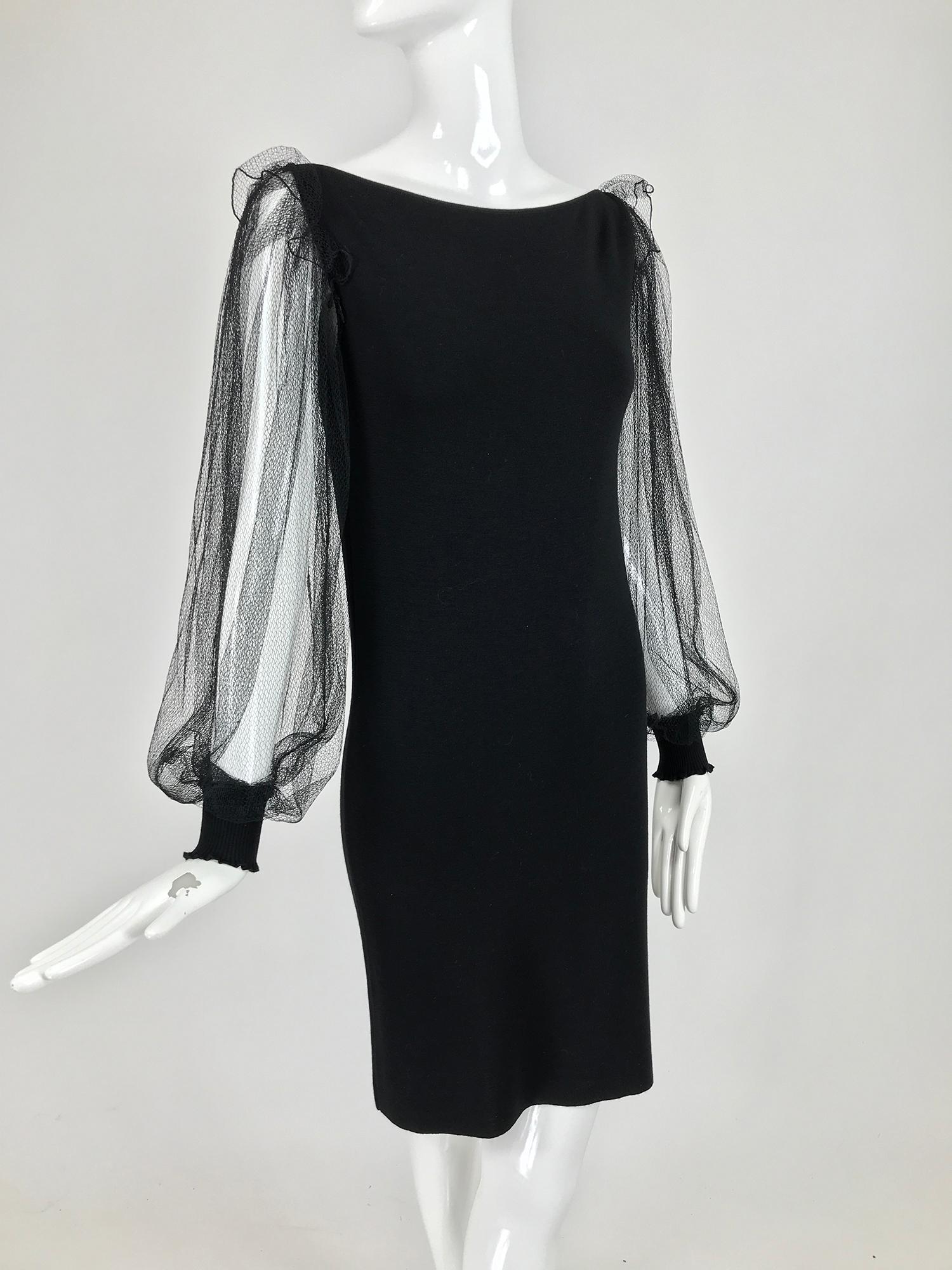 Loris Azzaro black stretch wool/cashmere knit sheath dress with long full black net sleeves. This amazing dress has a bateau neckline the dress hugs the body with a bit of stretch, the sleeves of fine black net attached at the shoulder with a ruffle