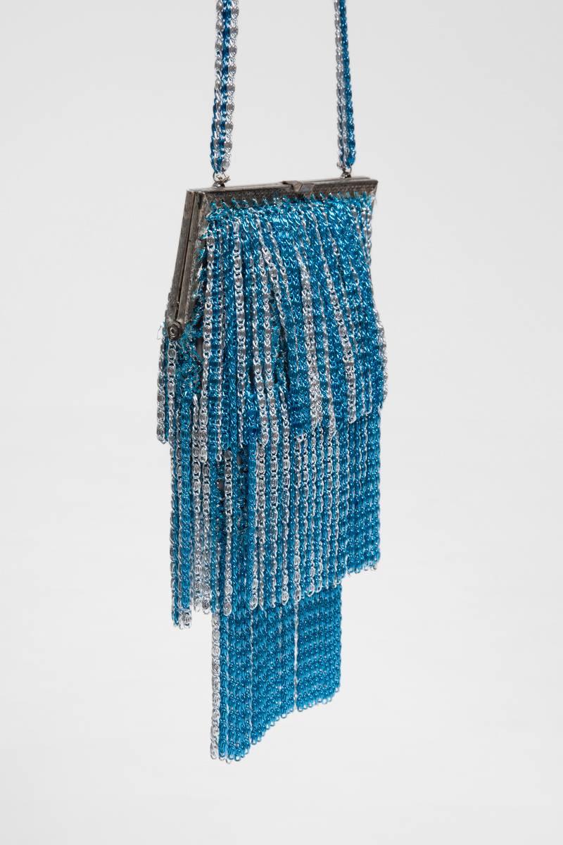 Rare sac à bandoulière Loris Azzaro des années 70. Fabriqué de la même manière que ses célèbres hauts en crochet tricotés en Lurex, le sac est de couleur turquoise et argentée et garni de trois rangées de franges en cotte de mailles assorties. Bords