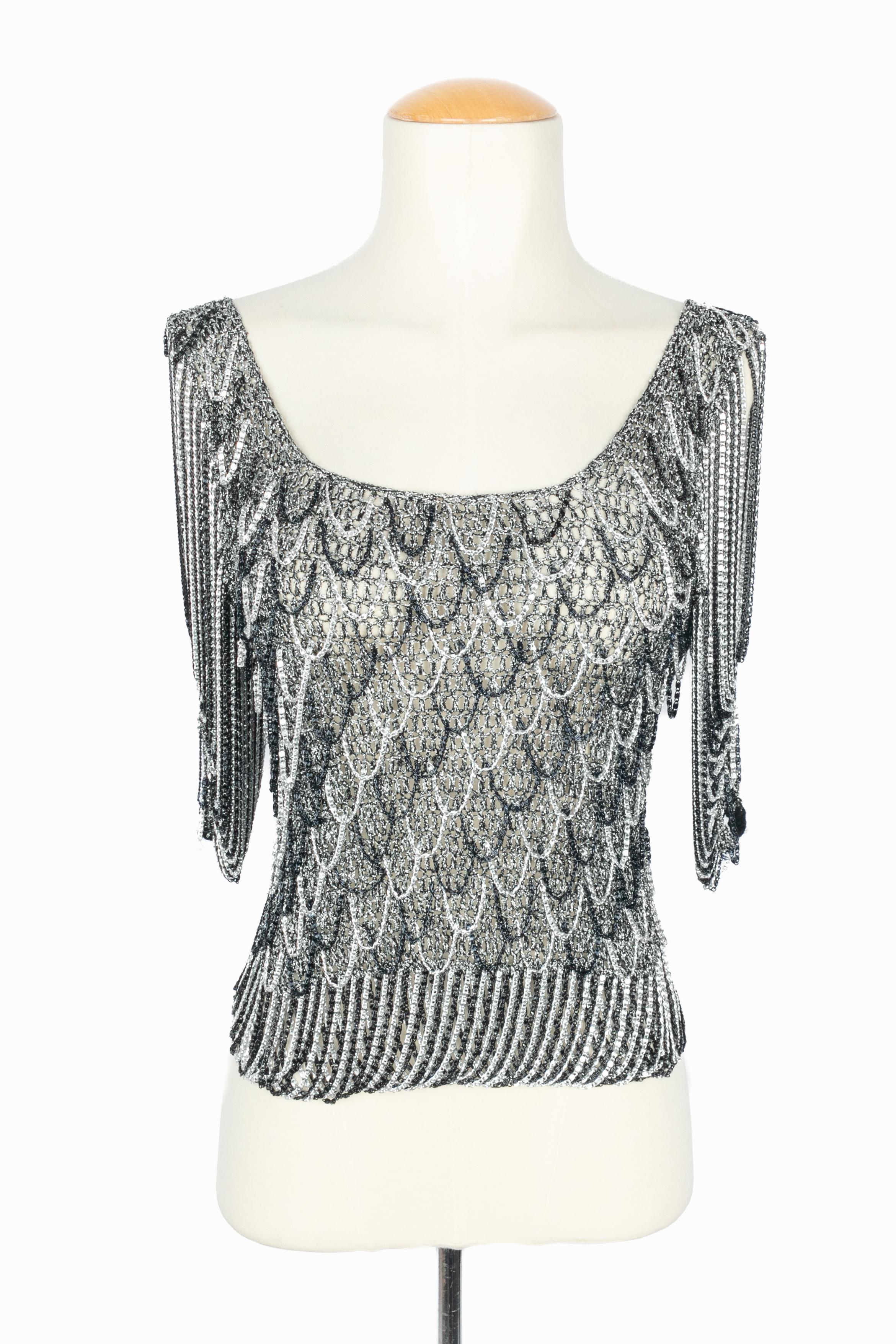 AZZARO - (Made in France) Top in rete nera e argentata con lurex e piccole catene. Mancano le etichette della composizione e della taglia, ma veste una 36FR. Un pezzo degli anni '70 sotto la direzione artistica di Loris Azzaro.

Condizioni:
Ottime