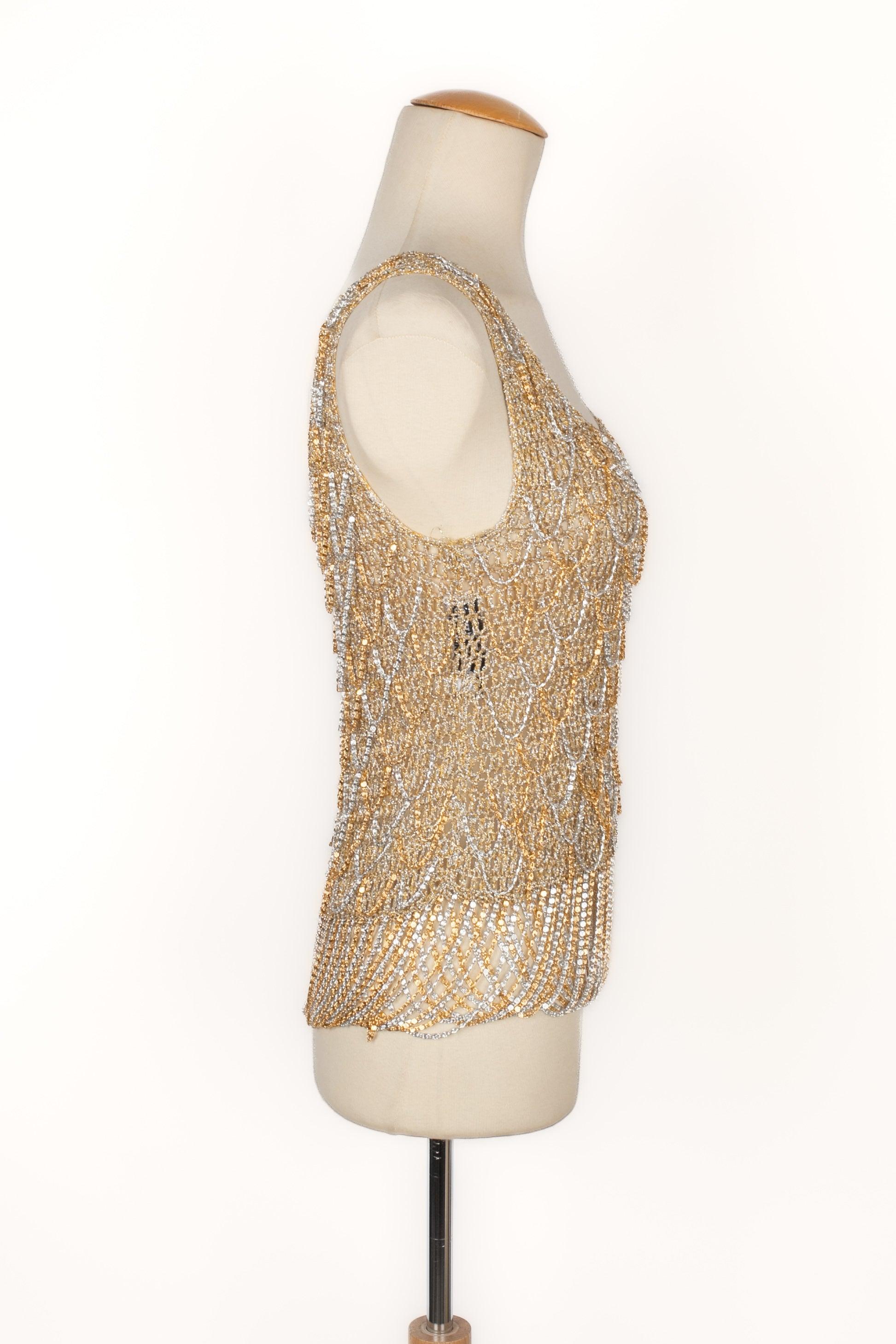 Azzaro - (Made in France) Golden and silvery top ornamented with chains, from the 1970s. No size indicated, it fits a 36FR.

Additional information:
Condition: Very good condition
Dimensions: Chest: 38 cm - Length: 58 cm
Period: 20th Century

Seller