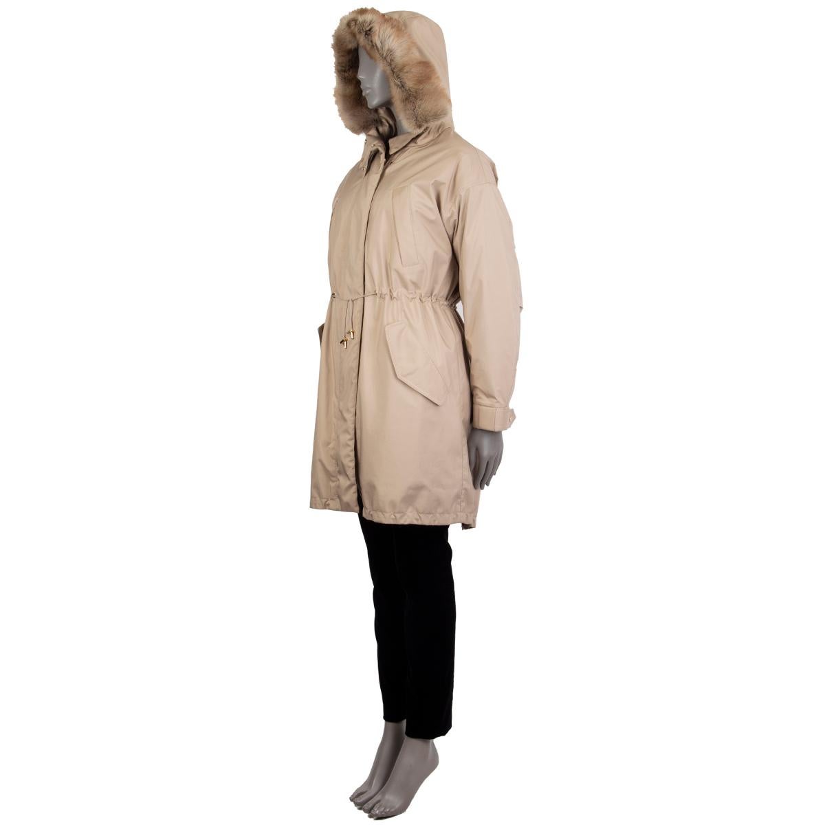 Loro Piana hooded down parka in beige polyester (80%) and polyurethane (20%) with goose down filling. Features American marten fur trim around the hood, drawstring around the hood, waist, and hemline, two chest pockets, two buttoned flap pockets on