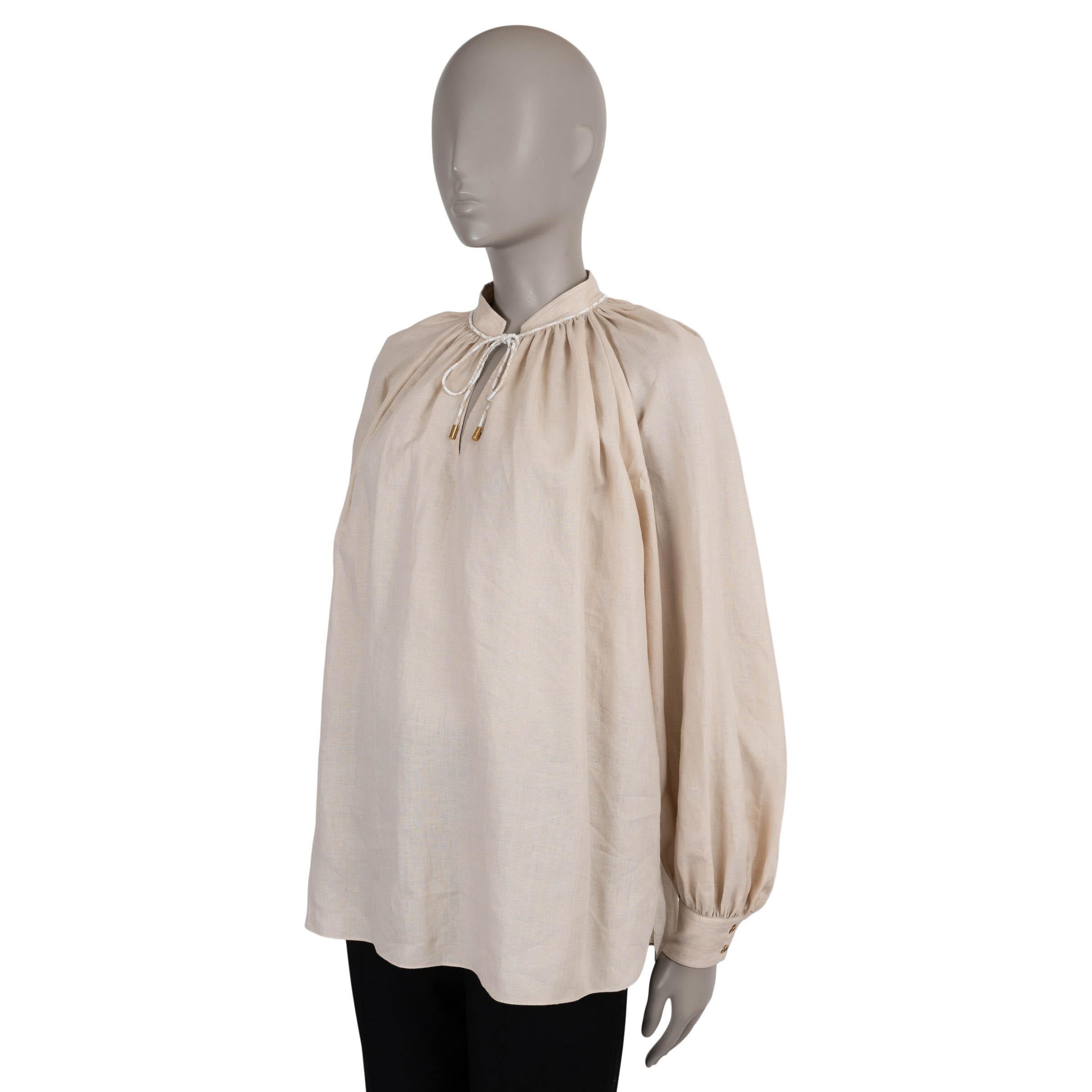 This 100% authentic Loro Piana Molly blouse is crafted in Clear Sea Shell beige chambray linen (100%), offering the brand’s signature lightweight luxury. Designed with a relaxed silhouette, it features a slit band collar with a delicate self-tie
