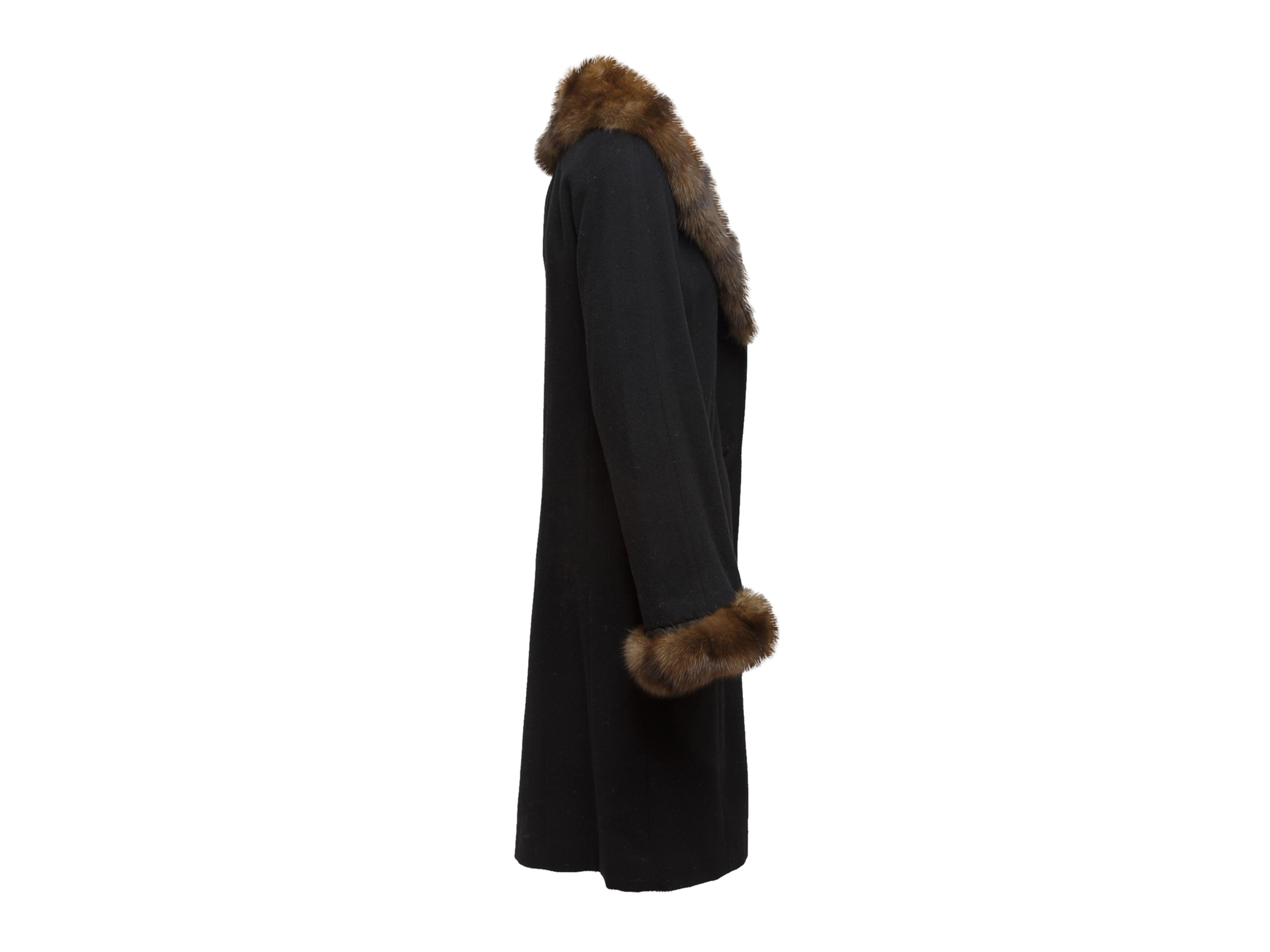 Product details: Black custom cashmere winter coat made with authentic Loro Piana material. Sable fur trim throughout. Long sleeves. Dual pockets at hips. Button closures at center front. 36