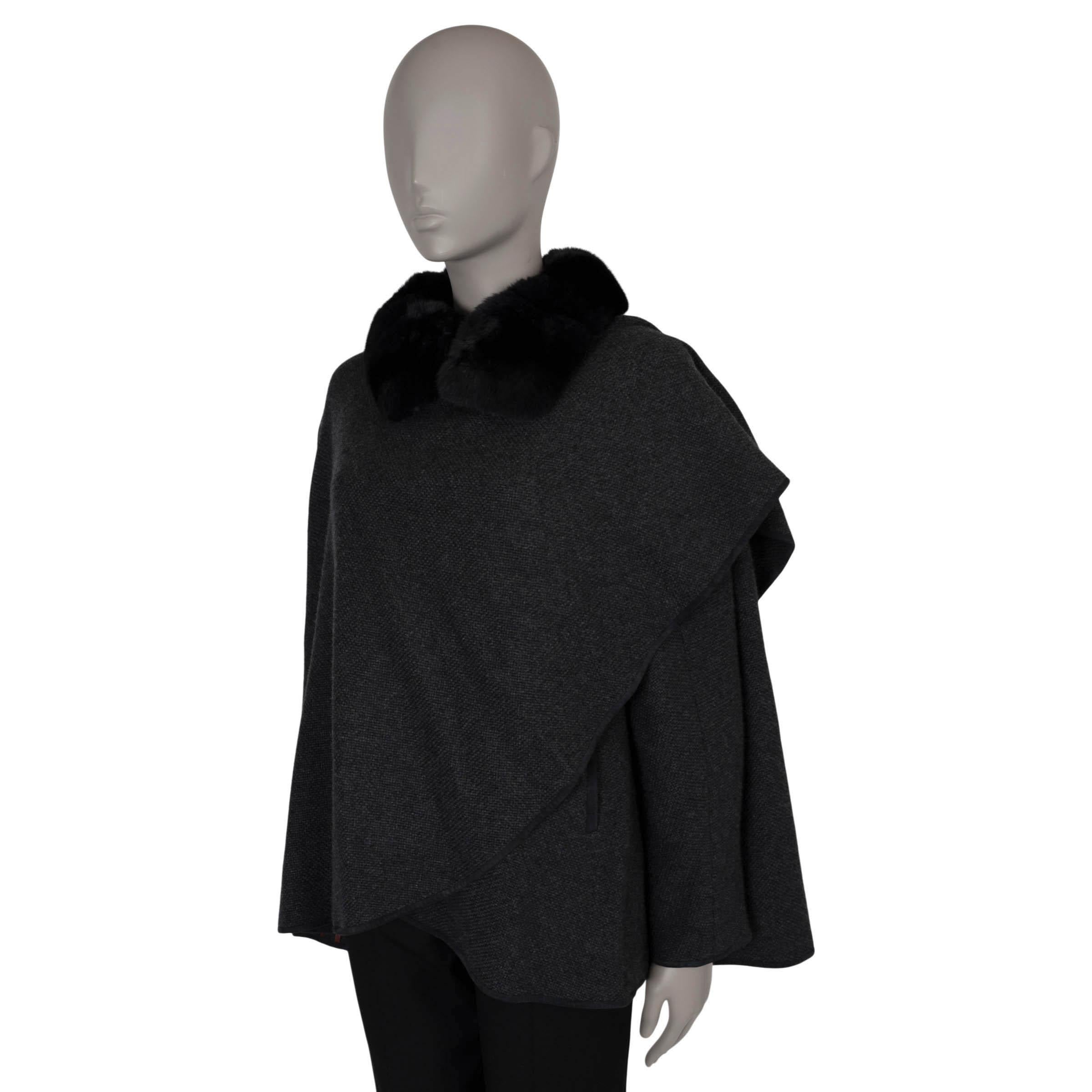 This 100% authentic Loro Piana wrap cape in charcoal grey cashmere exudes classic chic elegance. It features a luxurious black chinchilla fur collar and refined suede trims, adding sophistication to its timeless design. With practical slit pockets