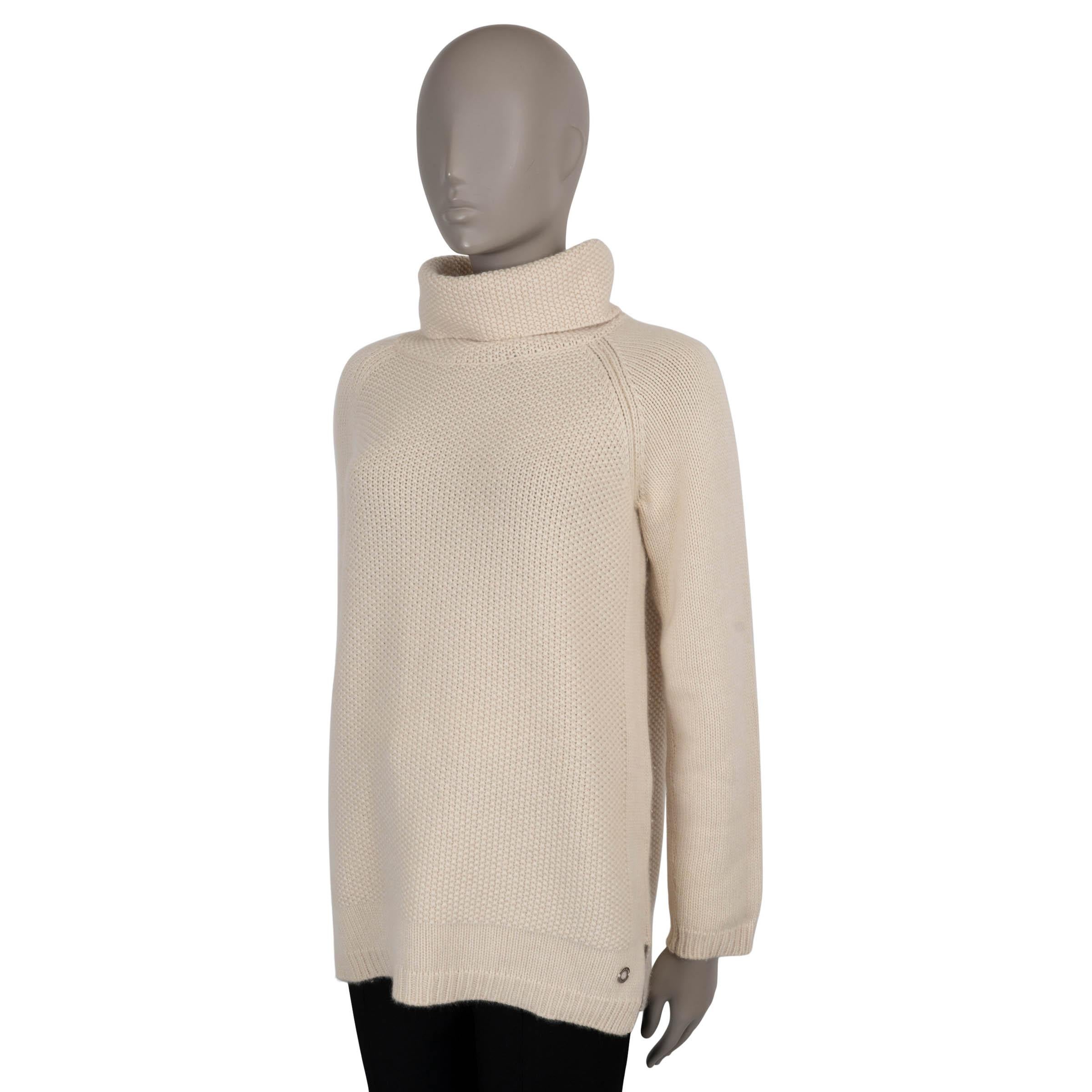 Este jersey 100% auténtico de Loro Piana está confeccionado en cachemira baby de color crema puro, apreciada por su excepcional suavidad y calidez. Presenta un sofisticado diseño de punto mixto con una textura más gruesa en el centro y el escote,