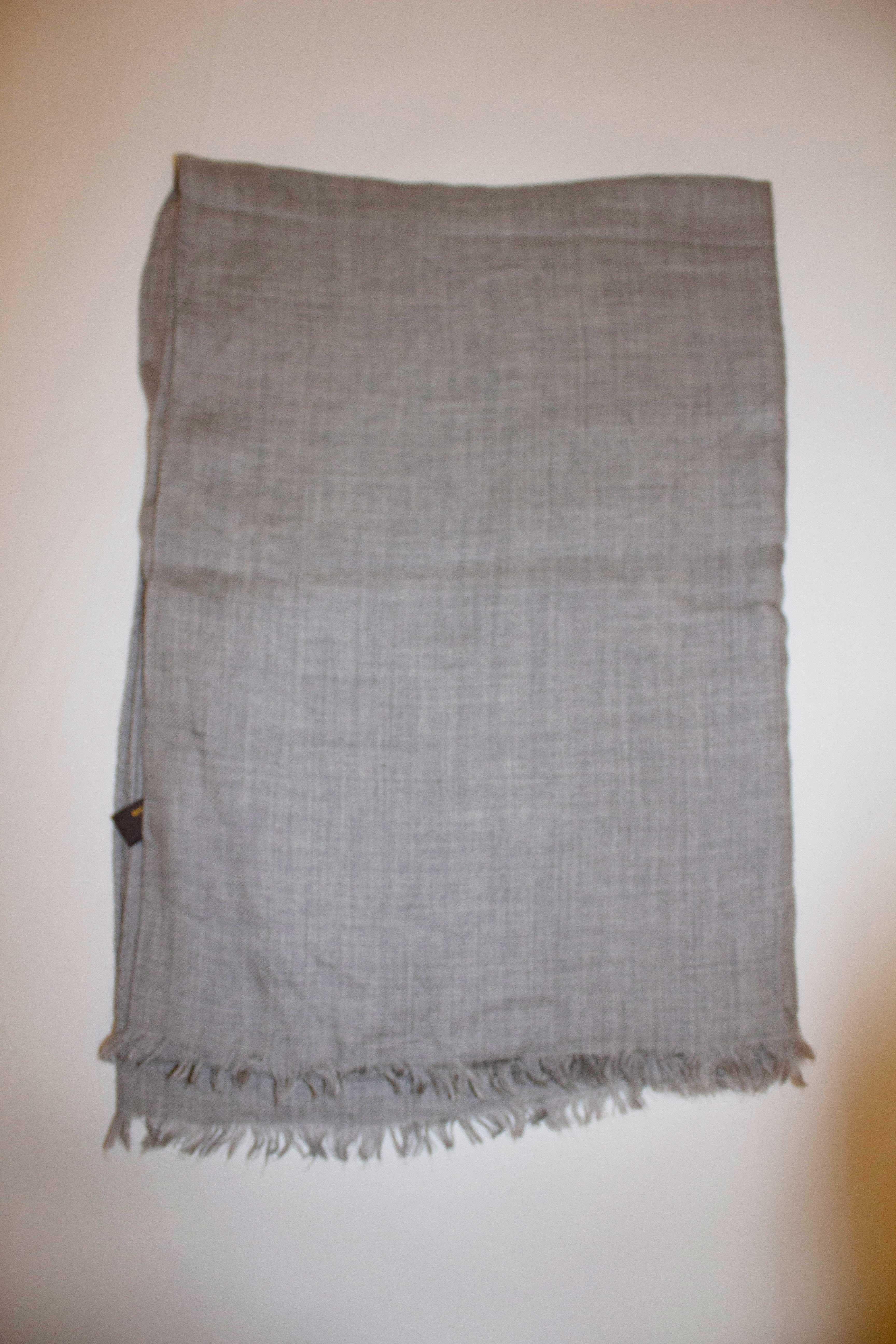 A very pretty and super soft scarf by Italian luxury house Loro Piana. In a cashmere ( 70% ) and silk ( 30 % ) mix, the scarf is in a pretty shade of grey with short fringing. 
Measurements: Length 80'', width 28''