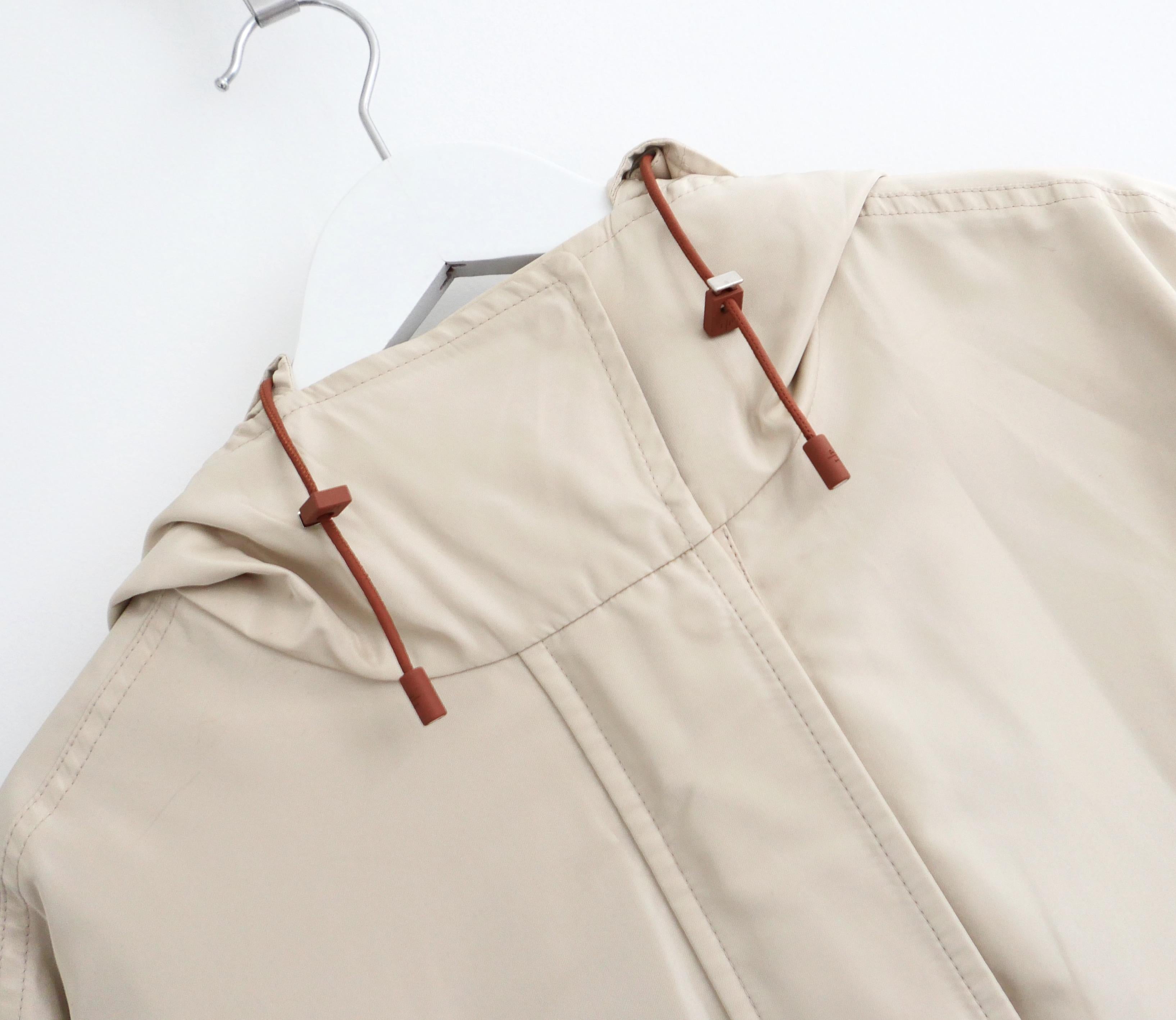 Super luxe, l'imperméable Headley de Loro Piana.  Acheté pour £3250 et porté une fois. Confectionné en satin beige mat super doux et léger, il présente une coupe ample avec cordon de serrage à la taille, des poches obliques et une capuche ajustée