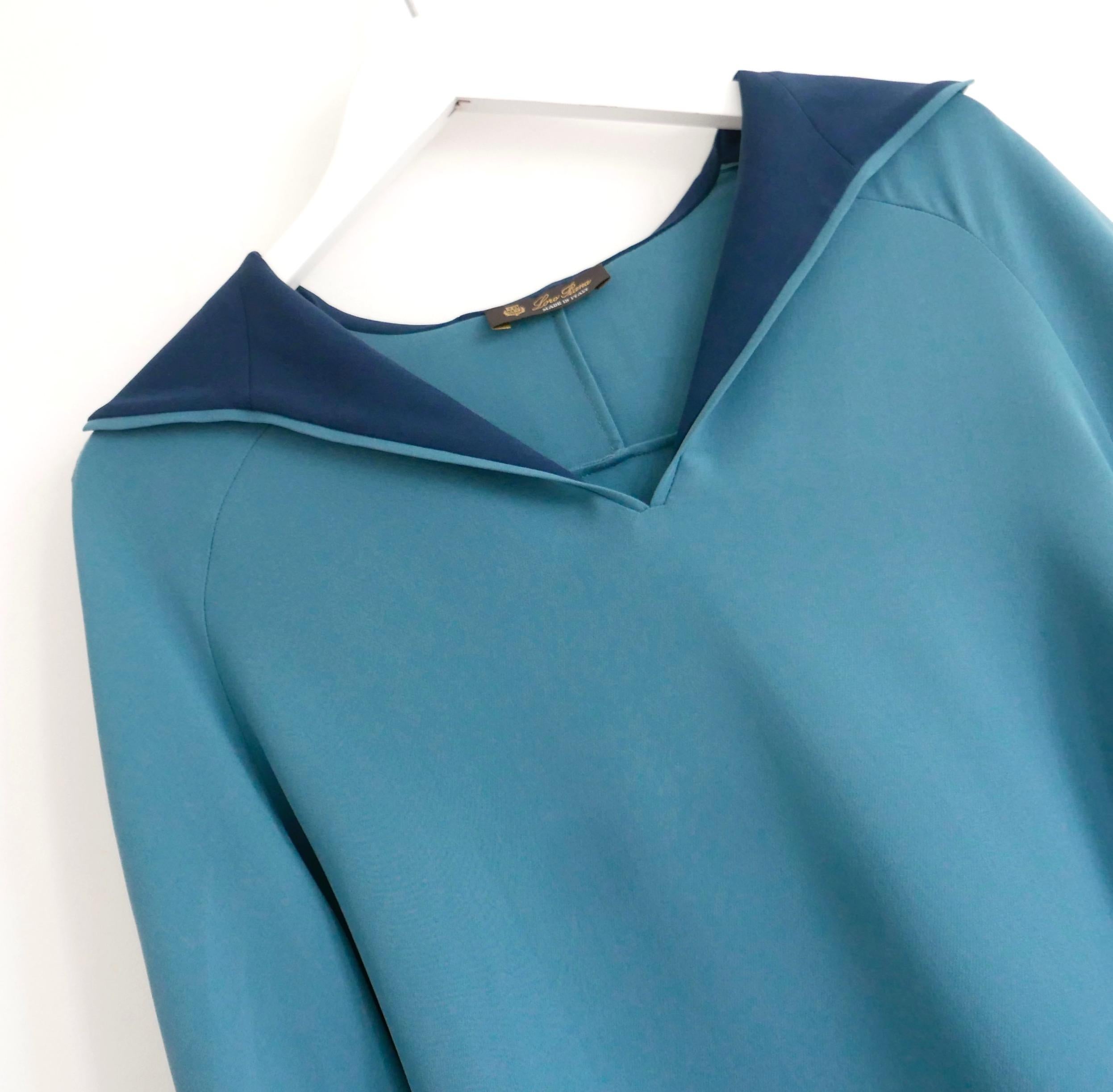 Gorgeous Loro Piana Isida blouse. Bought for £1400 and new with tags. Made from fluid turquoise blue silk crepe de chine with navy silk trims. It has a fluid, flowing fit with V-neck, soft hood and ribbed jersey cuffs. Size IT36/UK4 and will fit