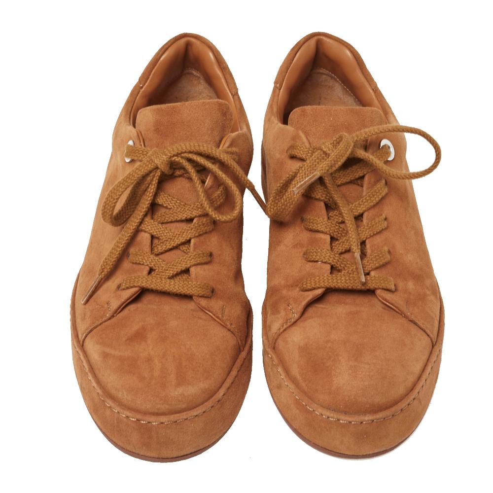 These simple yet stylish sneakers by Loro Piana are must-haves in the wardrobe of a fashionista like you. Rendered in suede, they flaunt a light brown hue, round toes, and laces on the vamps. Style them with flared pants and match the t-shirt with