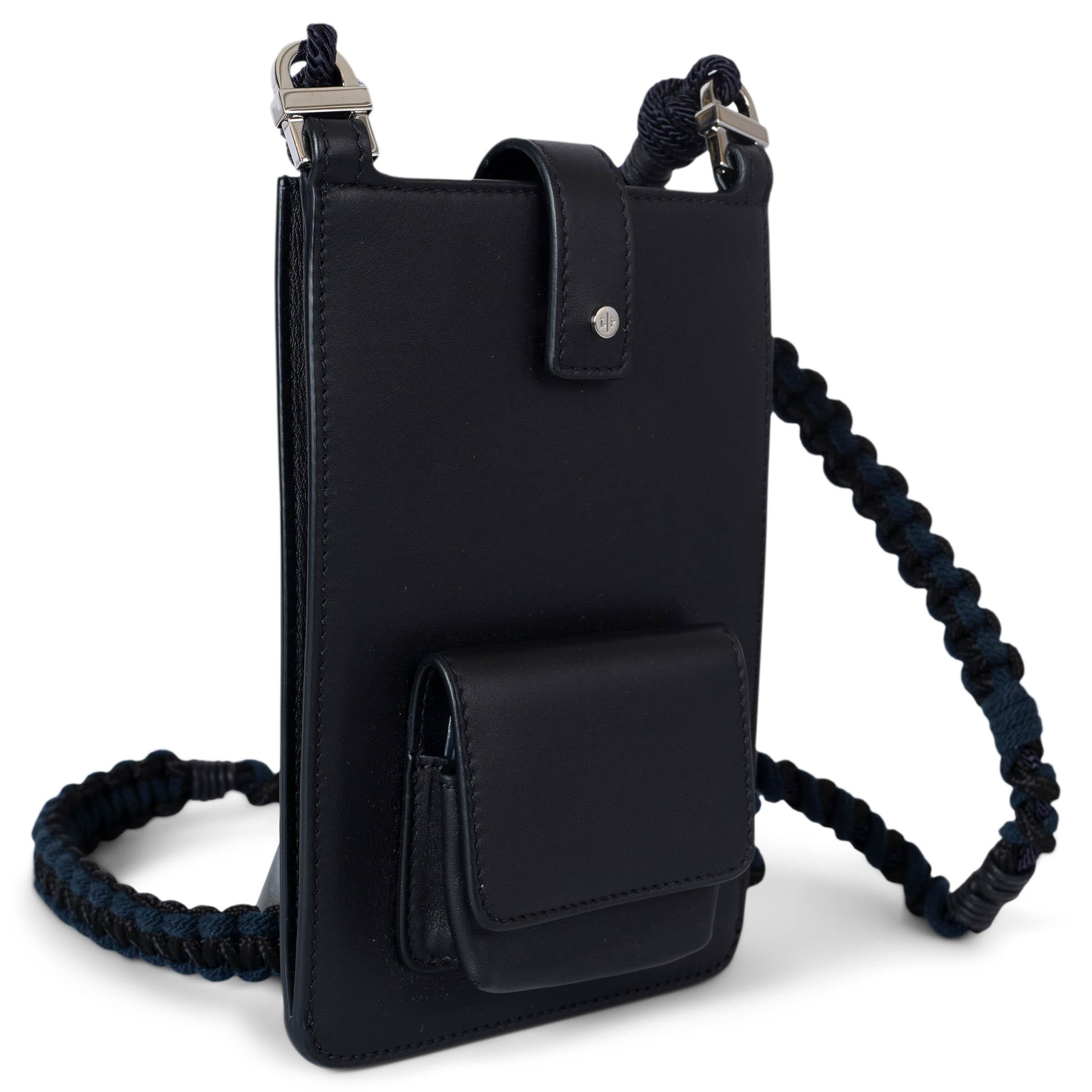 This 100% authentic Loro Piana Forget Me Not phone pouch is crafted from midnight blue leather and features silver-tone hardware. It includes a mini flap pocket with a snap button on the front, four credit card slots on the back, and interchangeable