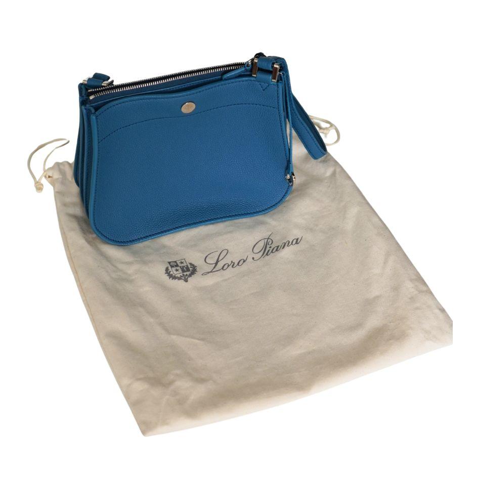 Cerulean leather Loro Piana Milky Way bag with silver-tone hardware, adjustable flat shoulder strap, three interior compartments; two with snap closures, tonal leather lining, single slip pocket at interior wall and zip closure at top. Includes dust