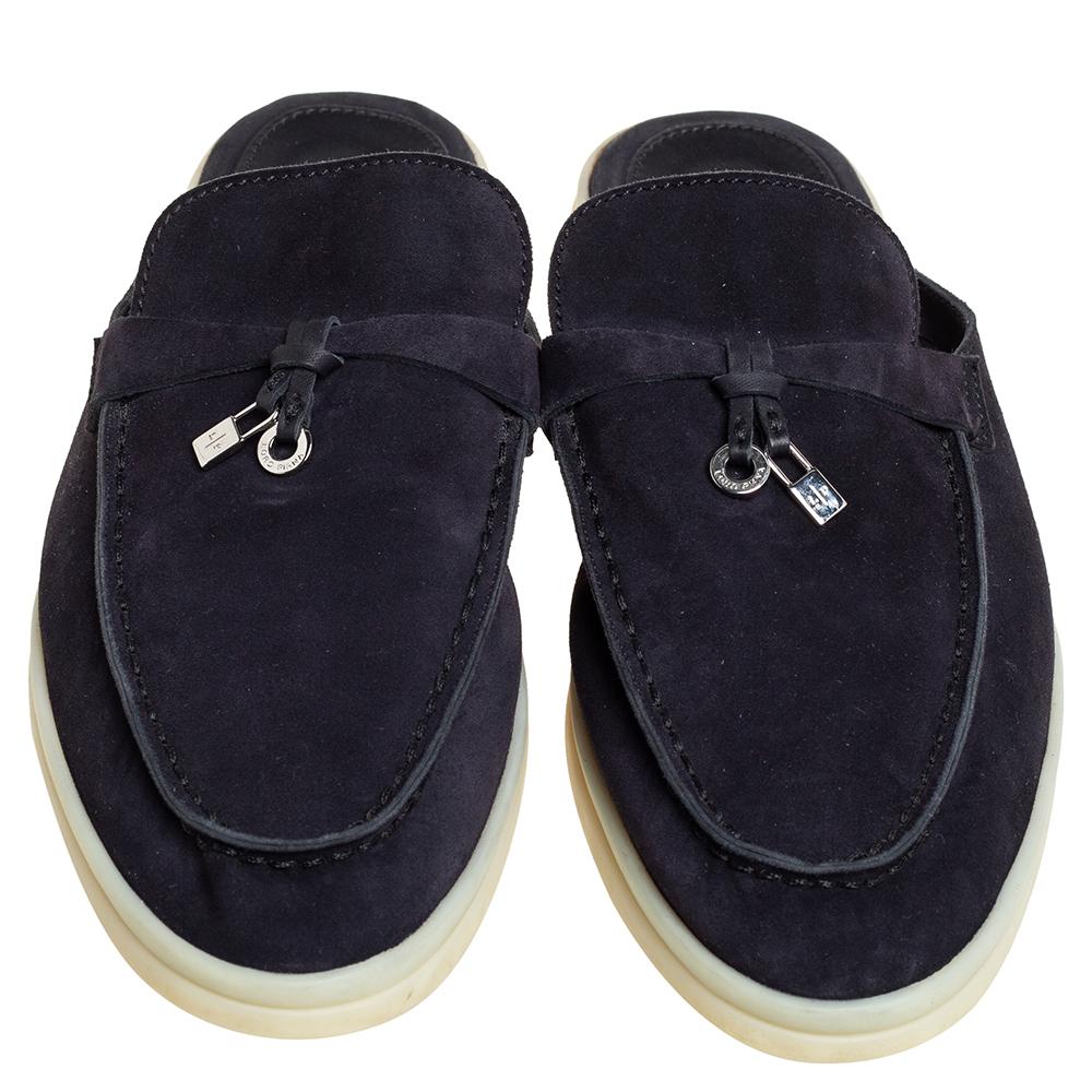 These navy blue Babouche Charms Walk mules from Loro Piana are crafted from suede and feature a neat design. They flaunt round toes, silver-tone padlock and ring charms on the vamps, comfortable insoles, and durable rubber soles.

