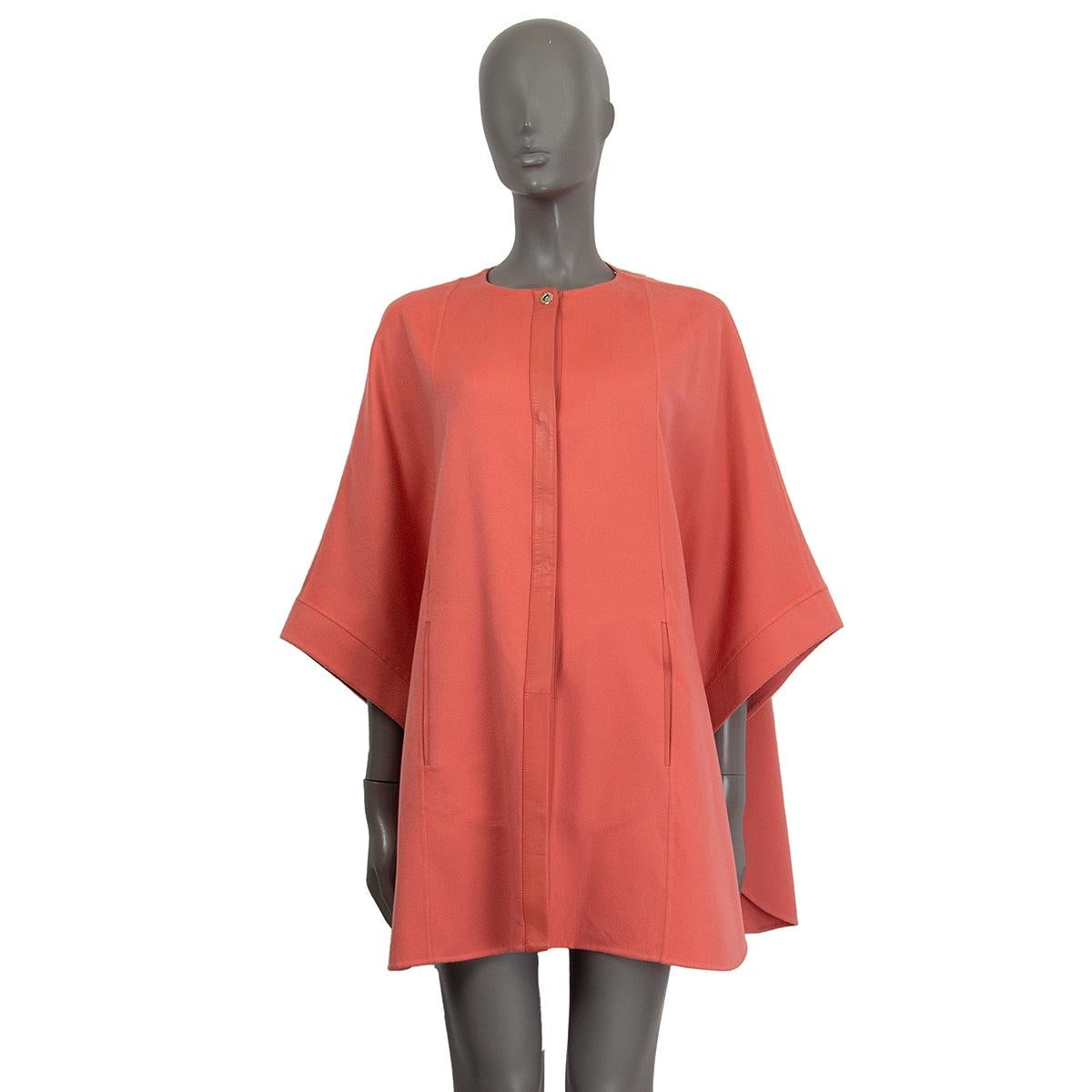 Loro Piana 'Margot' leather trim cape in salmon cashmere (100%) with a round neck and slit pockets. Closes on the front with snap buttons. Unlined. Has been worn and is in excellent condition. Short sleeves have a snap button closing at the botton