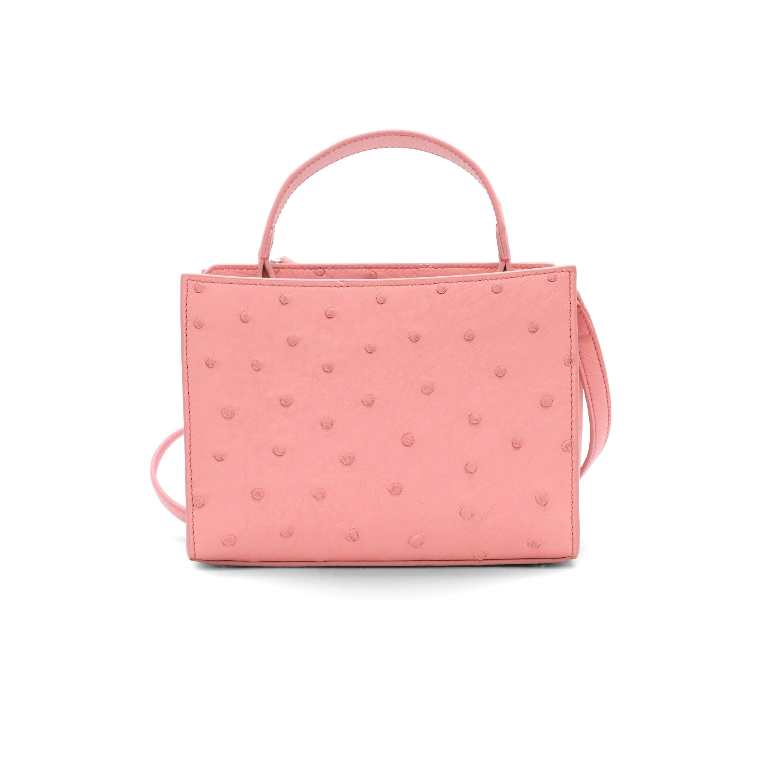 The Loro Piana Pink Ostrich Cluisee Top Handle Bag is a true symbol of luxury and craftsmanship. Crafted from exotic pink ostrich leather, this exquisite bag showcases Loro Piana's renowned attention to detail. The bag features silver-tone hardware