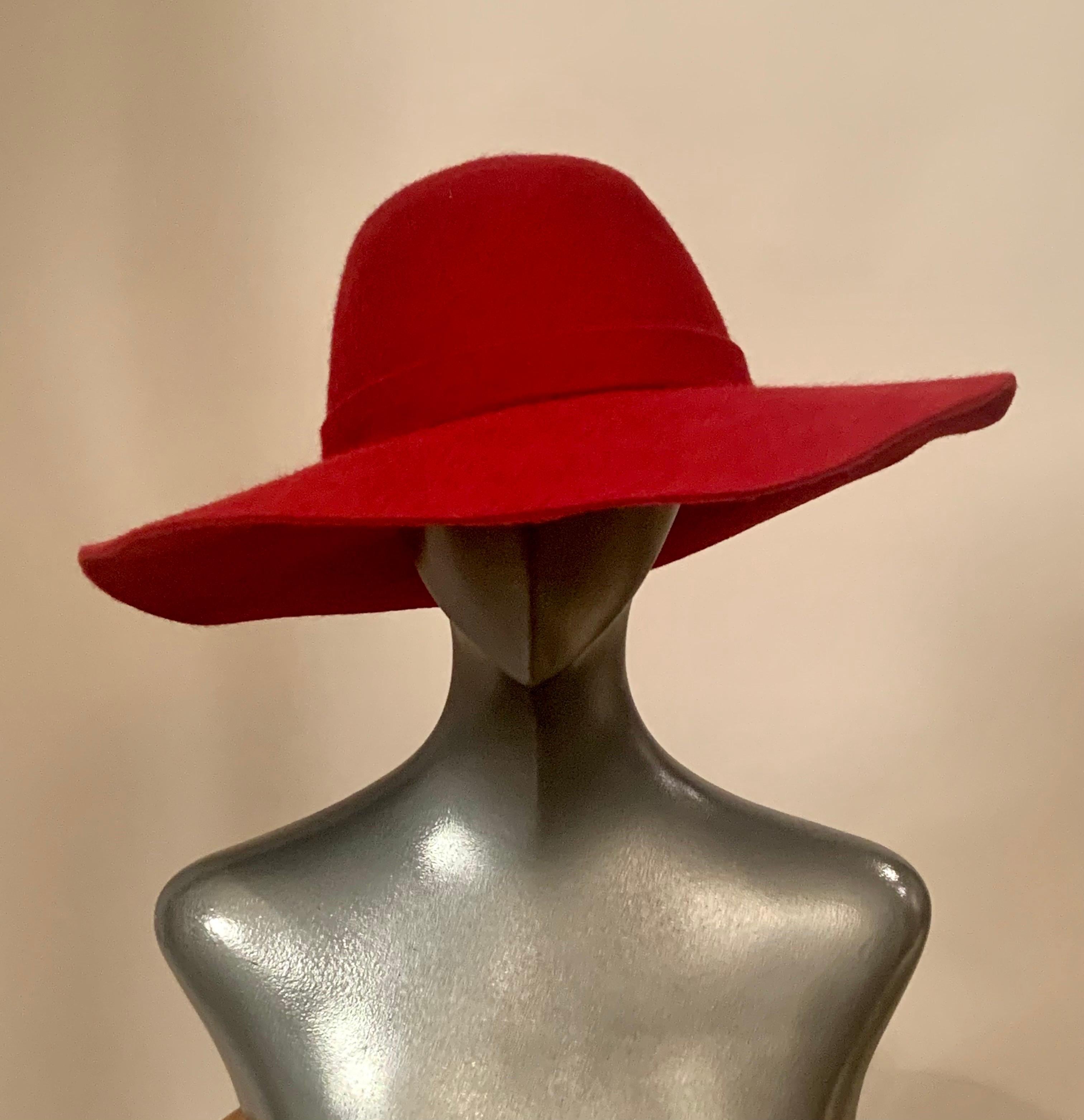 A flattering raspberry red wool and cashmere blend is used to make this lovely wide brimmed hat from Loro Piana.  It has a hat band made from the same fabric trimmed with a gold toned Loro Piana logo tag on a leather square. The Loro Piana label is