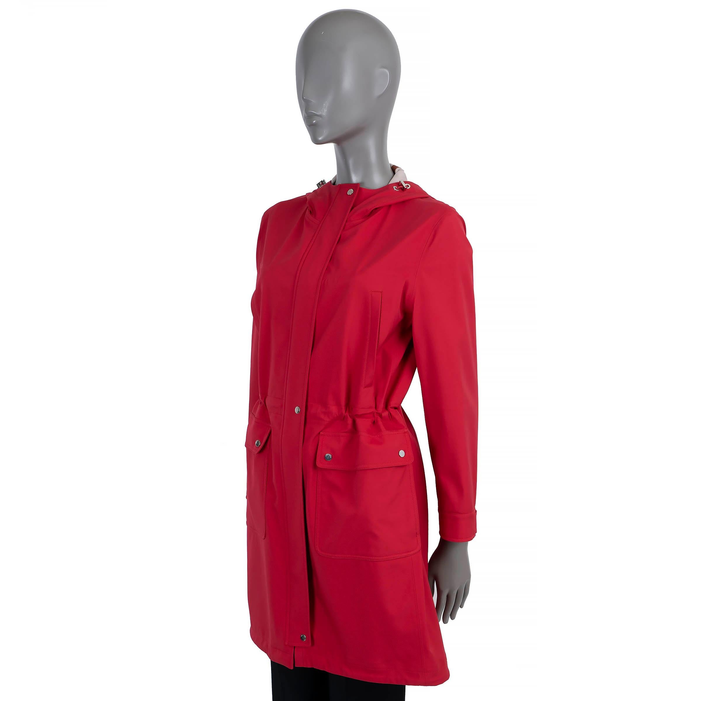 100% autentico impermeabile Loro Piana in poliestere rosso brillante (100%) - tessuto Storm System a tre strati. Presenta un cappuccio e una vita con coulisse, due tasche oblique sul petto e due tasche con patta in vita. Si apre con una cerniera