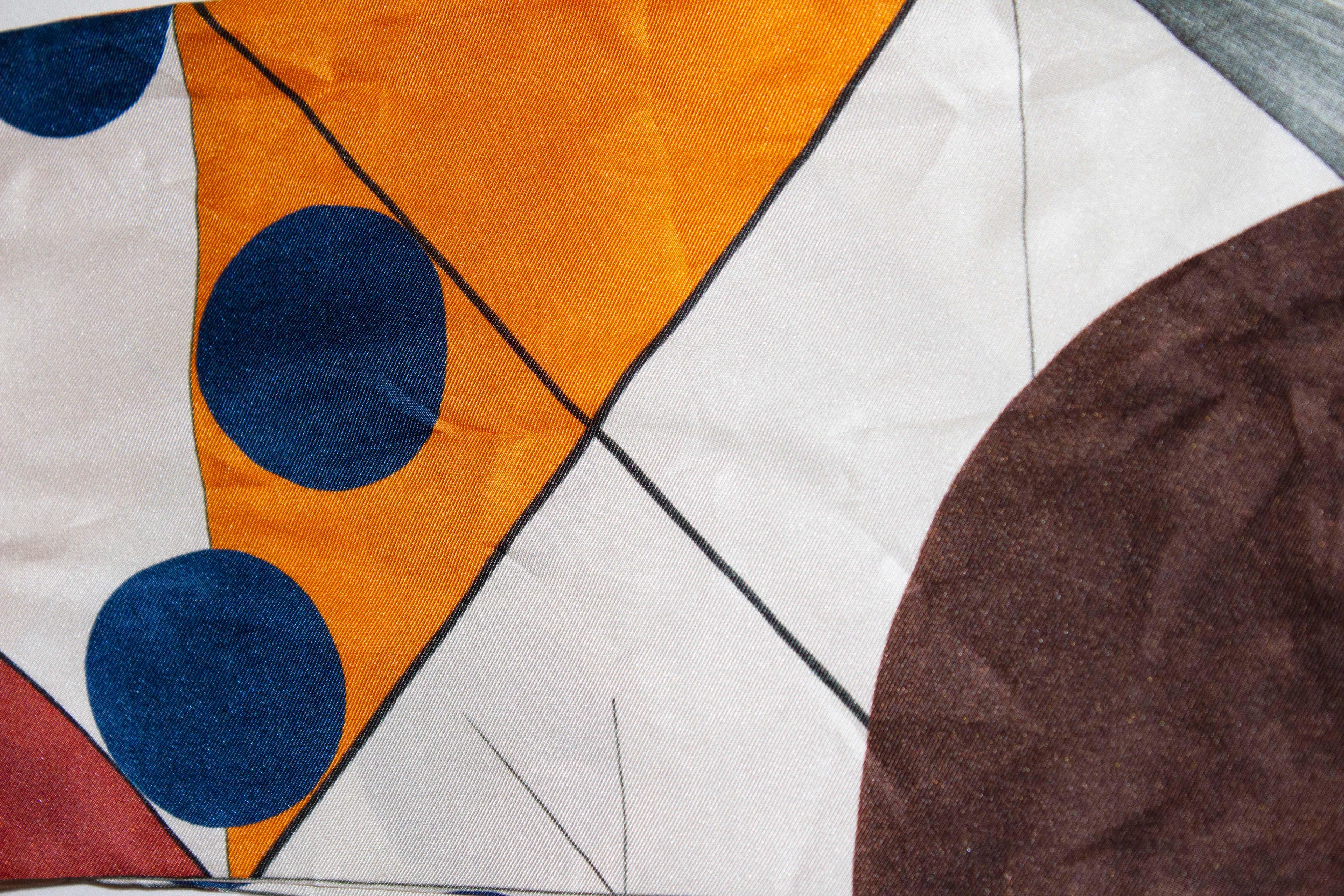 A lovely silk scarf by Loro Piana, in shades of orange, blue , brown , grey and white. Measurements: width 6 3/4'',length 50''