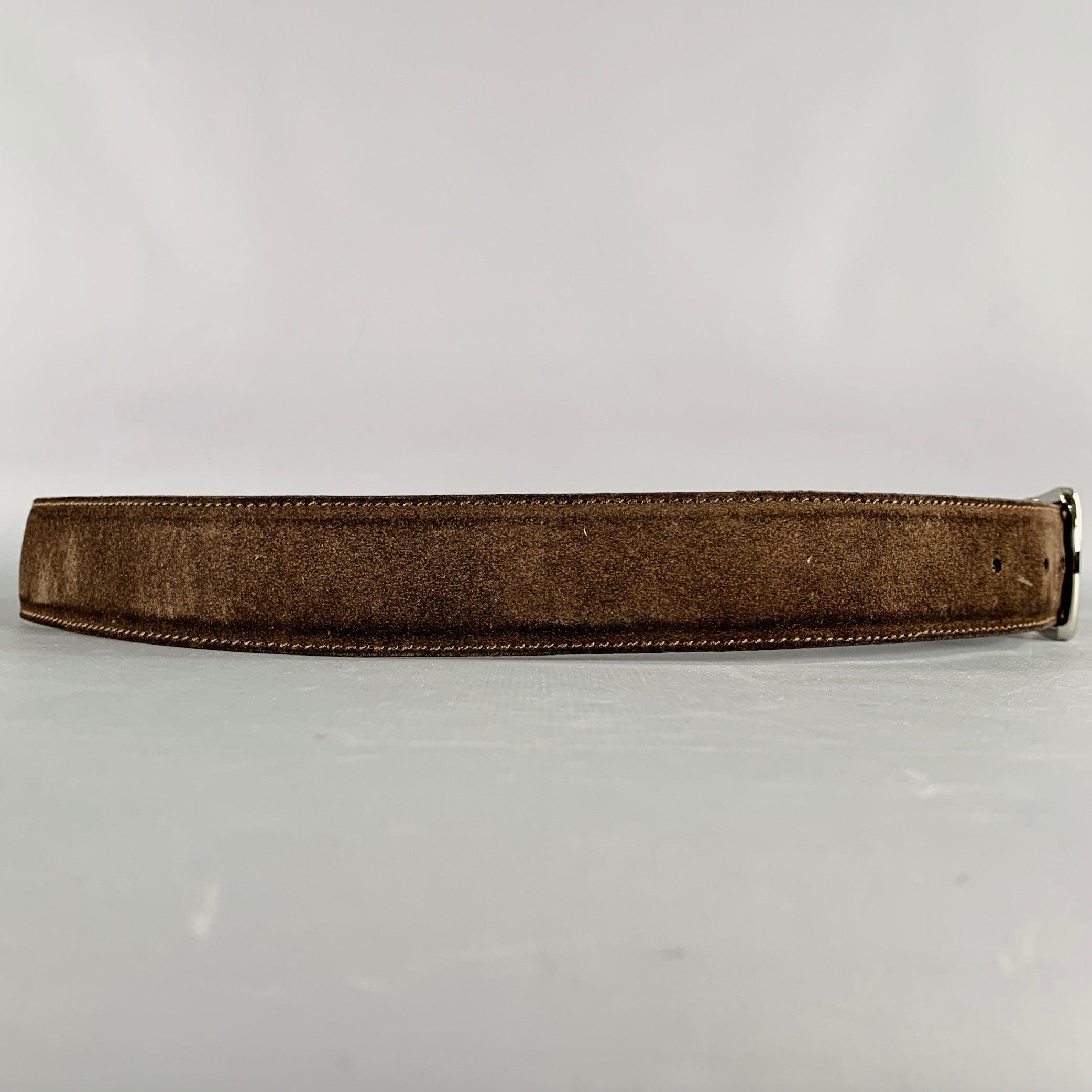 Ceinture LORO PIANA
en daim marron foncé avec une boucle en métal argenté. Fabriqué en Italie. Bon état d'usage. De nouveaux trous ont été percés dans la ceinture, en l'état. 

Marqué :   95/38Longueur : 42.75 pouces Largeur : 1.25 pouces Convient :