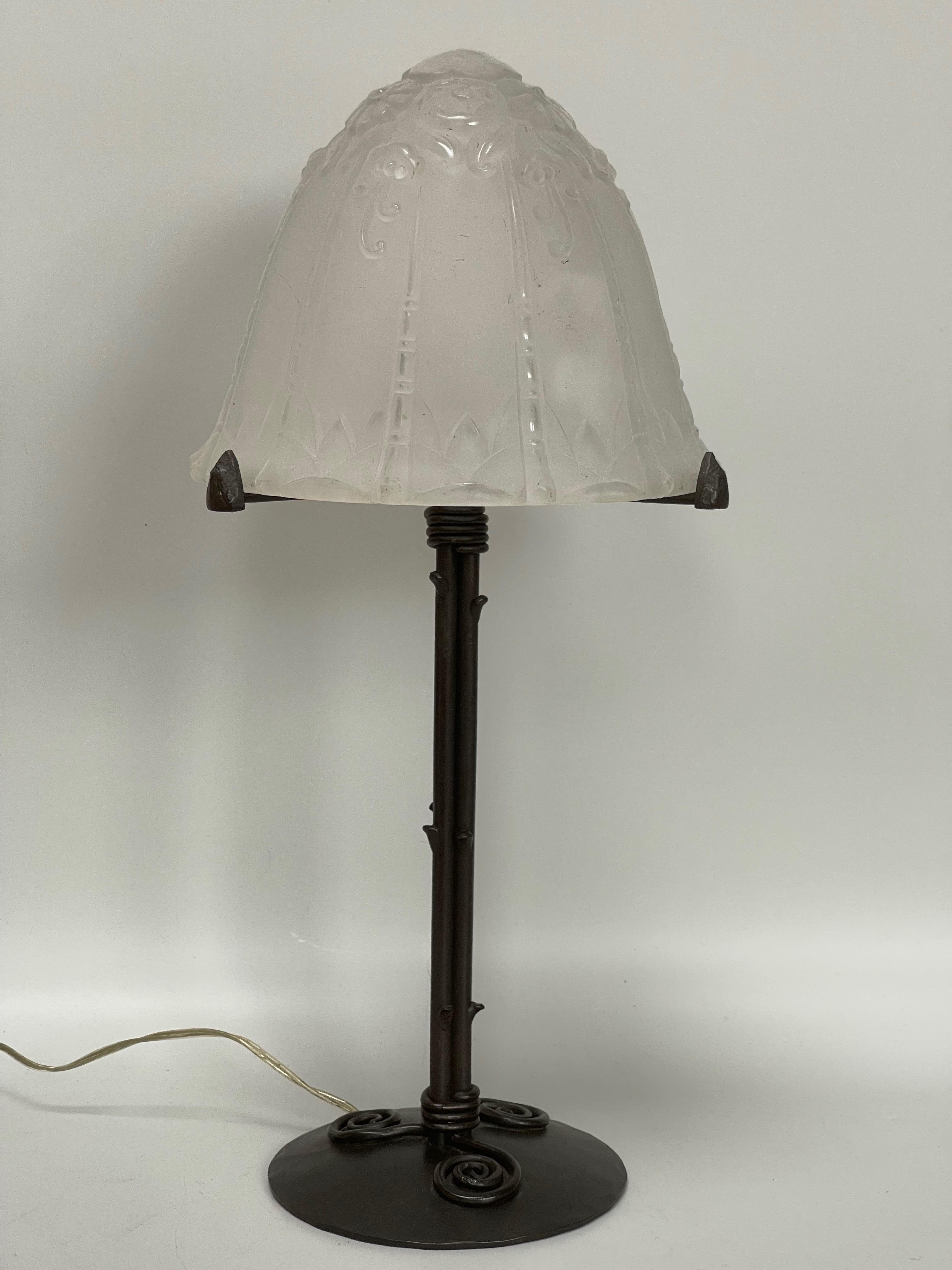 Art deco lamp circa 1930.
Wrought iron foot stamped Robert.
Molded glass shell with unsigned floral decoration. This model is very well known in Lorraine.
Electrified and in very good condition.

Total height: 37 cm
Base diameter: 12 cm
Shell
