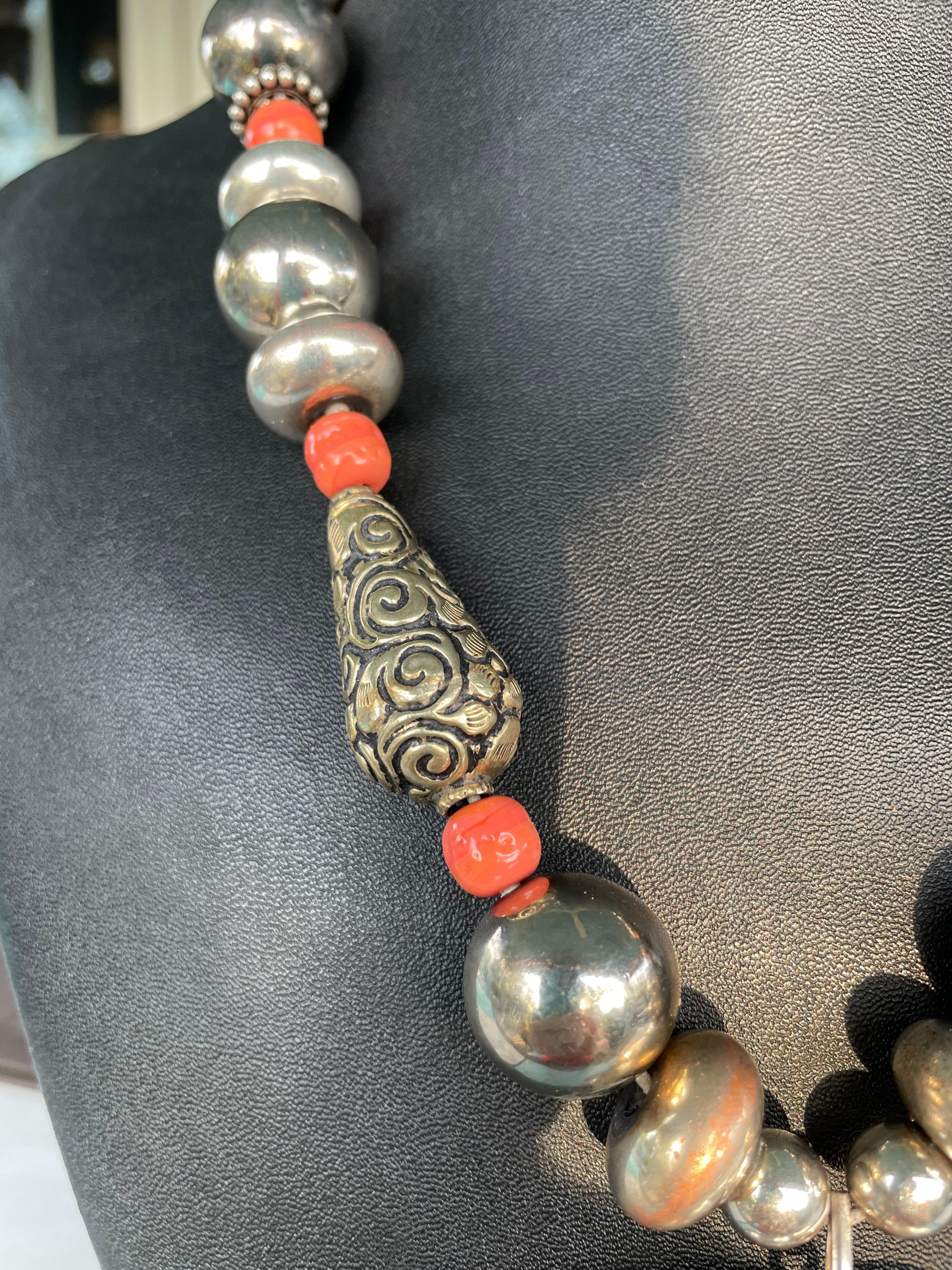 Lorraine’s Bijoux offers a one of a kind, handmade, Statement  necklace.A large puffy, vintage, sterling silver heart acts as the centerpiece on a string of vintage coral glass ,vintage Mexican sterling beads, and Tibetan repousse  beads. Sterling