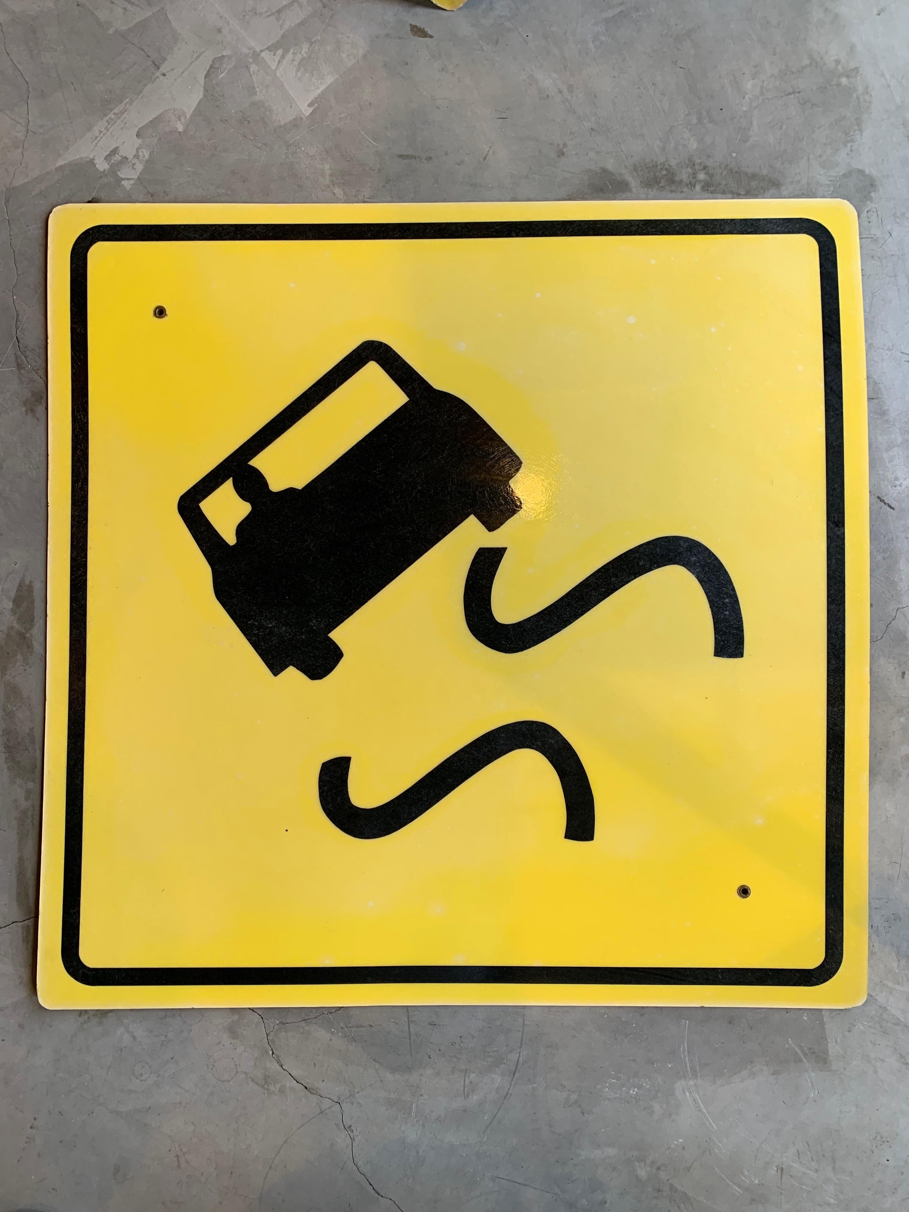 Vintage plastic road sign from Los Angeles. Slippery road ahead. Large in scale. Yellow background with black graphics. Cool piece of wall art.