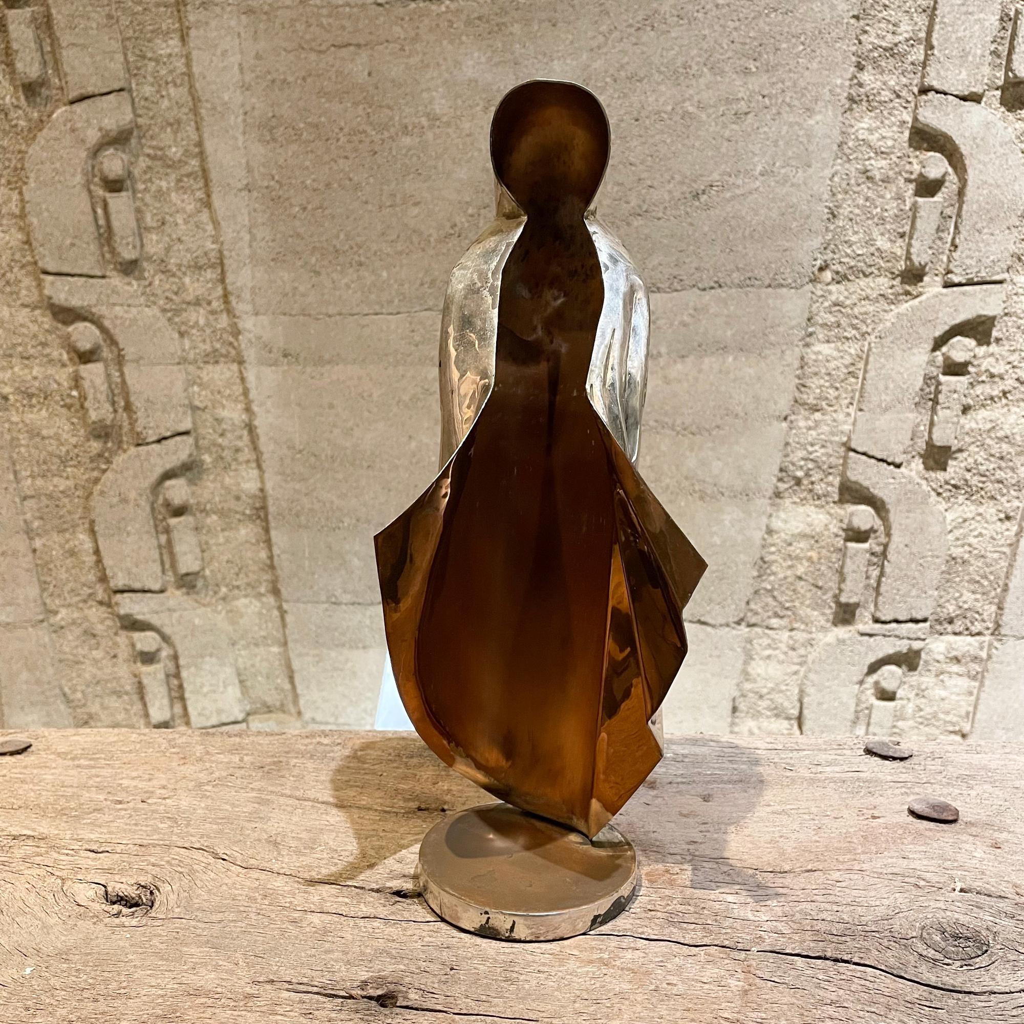Abstract sculptural virgin mary Guadalupe statue 1960s handwrought in Married Metals.
Measures: 14 H x 4 D x 5 W inches
Made in silver plate with married metals. Unmarked. Attribution Los Castillo of Taxco Mexico. 
Unrestored preowned vintage