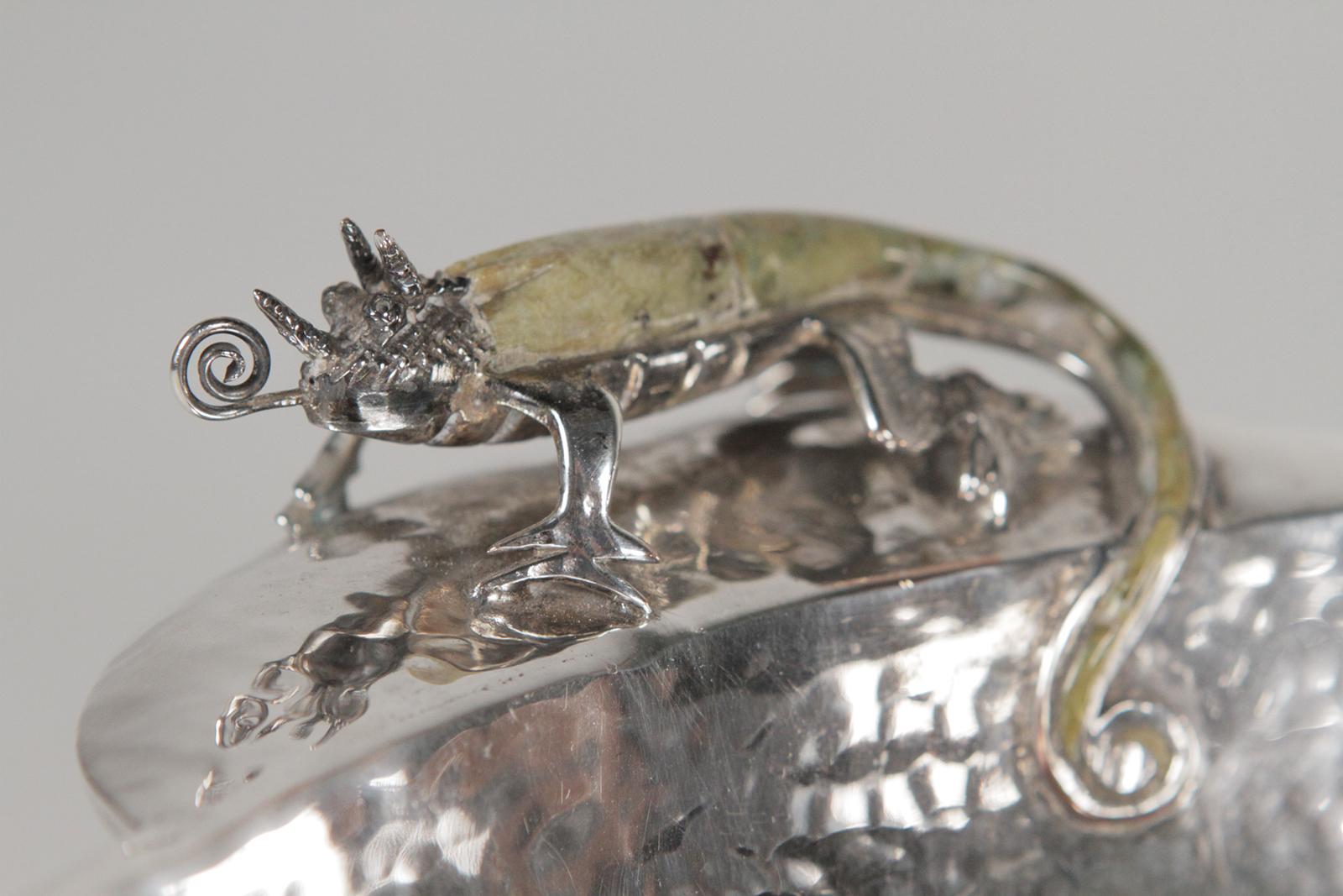 Los Castillo hand-hammered silver plated lizard bowl, 1960s. Handles have handcrafted lizard inlaid with green stone with horns and curling tongue. This is the rare larger size. 
The Castillo school was started by the Castillo brothers in 1939