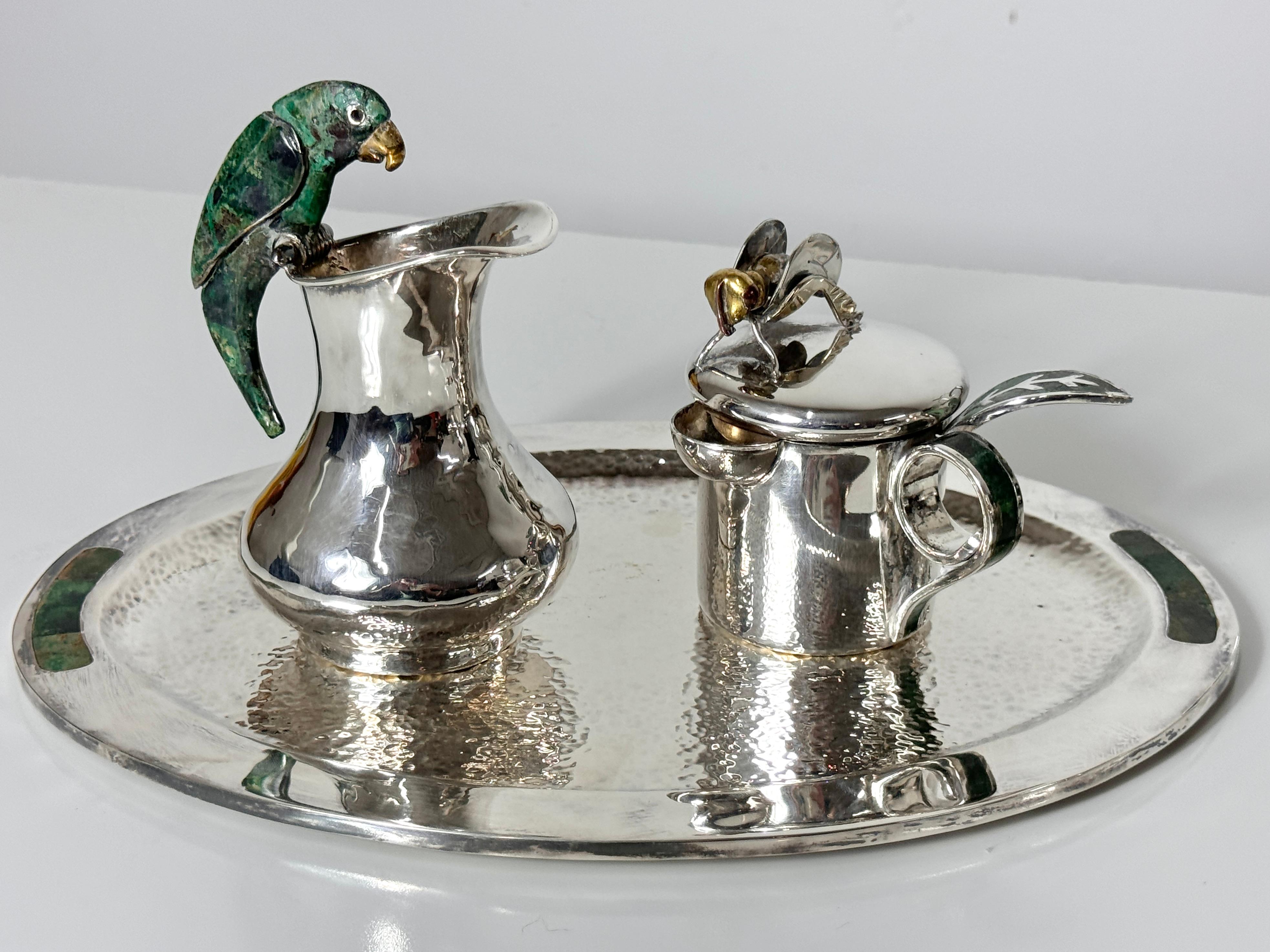 Exquisite three piece silver plate serving set by Los Castillo for Taxco
Mexico circa 1950s

Oval serving tray with turquoise inlay detail
Creamer with parrot handle in turquoise and brass
Sugar or honey pot with mixed metal bee and turquoise inlay