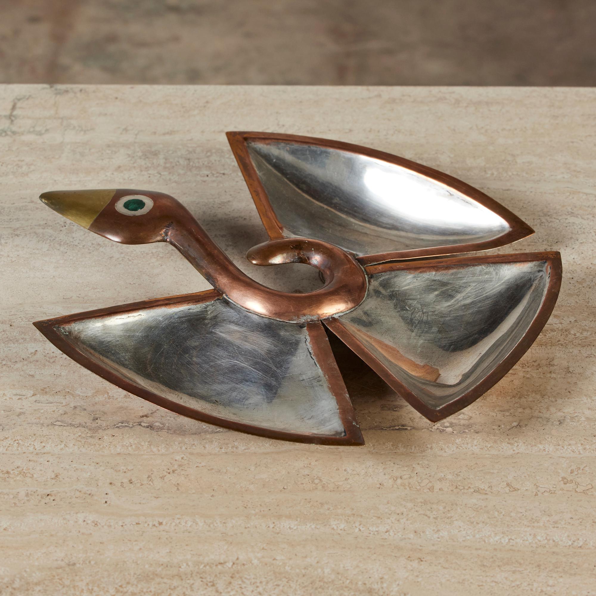 This Mexican made dish, c.1960s, is made of copper, brass and stainless steel. It's unique shape resembles a bird with sprawled wings in flight. It features three sectioned trays stemming from a copper curved neck and a dash of color, green, for the