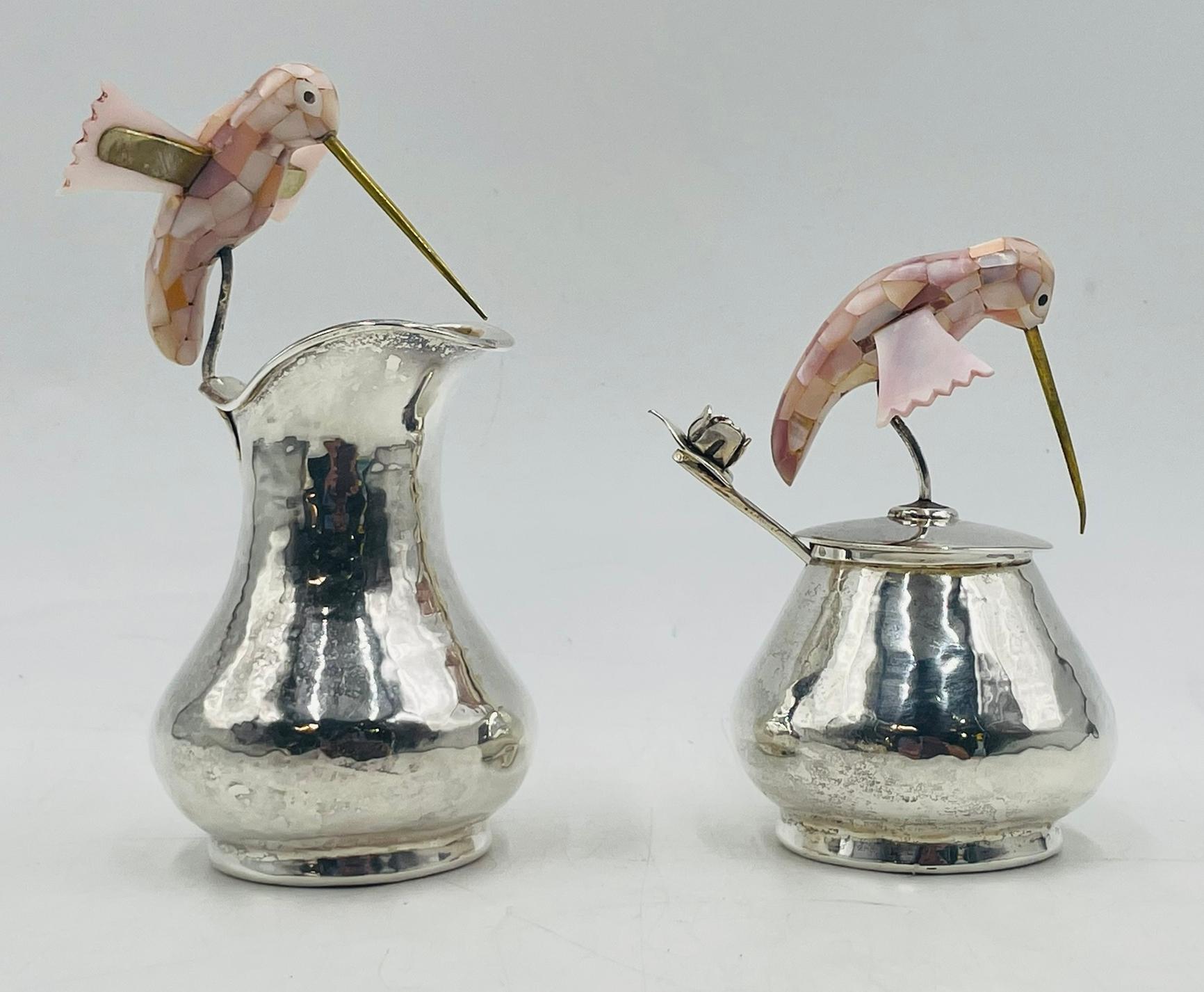Crémier, sucrier et louche assortis en argent de Los Castillo, fabriqués à la main à Taxco, au Mexique, vers les années 1960. Chaque récipient est rehaussé d'embouts de colibri finement détaillés, incrustés de nacre irisée et de becs en laiton,