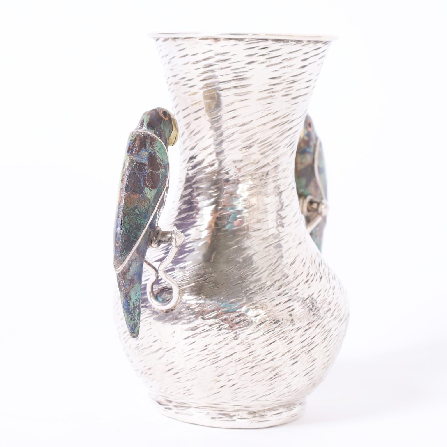 Vase ou récipient remarquable du milieu du siècle, fabriqué à la main en argent sur cuivre martelé, avec deux poignées en forme de perroquet recouvertes de pierre. Signé Los Castillo sur le fond.