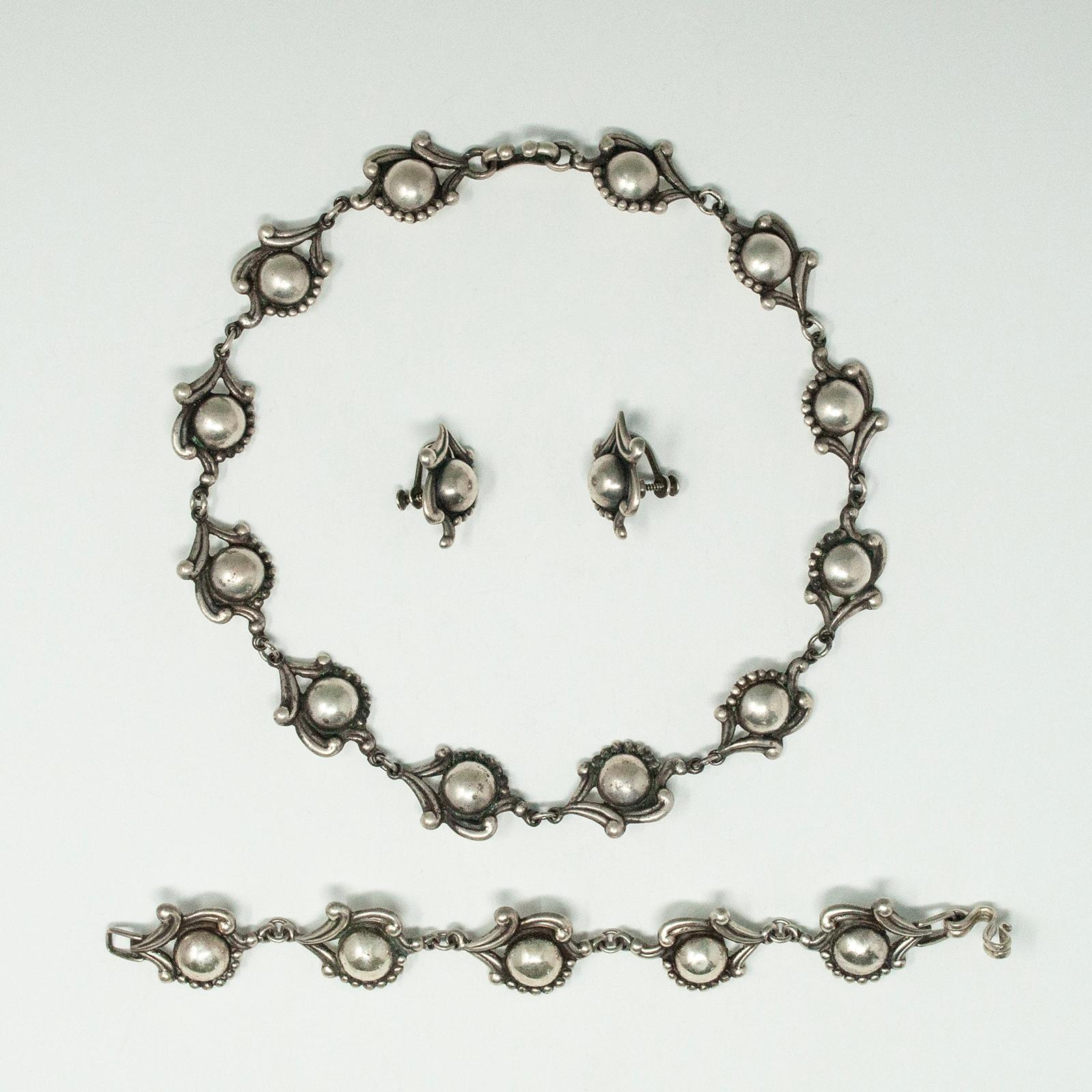 Ensemble collier, bracelet et boucles d'oreilles Los Castillo, poinçonné. L'argent est fortement repoussé. Il s'agit d'un magnifique motif à caractère floral. Design/One 595. Le collier et le bracelet se ferment par un crochet et les boucles