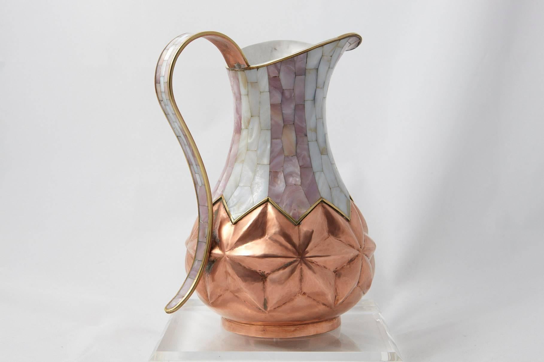 A very fine sample of traditional Mexican silversmith work, an exceptional hammered brass and silver plate pitcher with mother-of-pearl inlays from Los Castillo Taxco.
The pitcher is marked on the underside: TA-01, Hecha en Mexico, Los Castillo