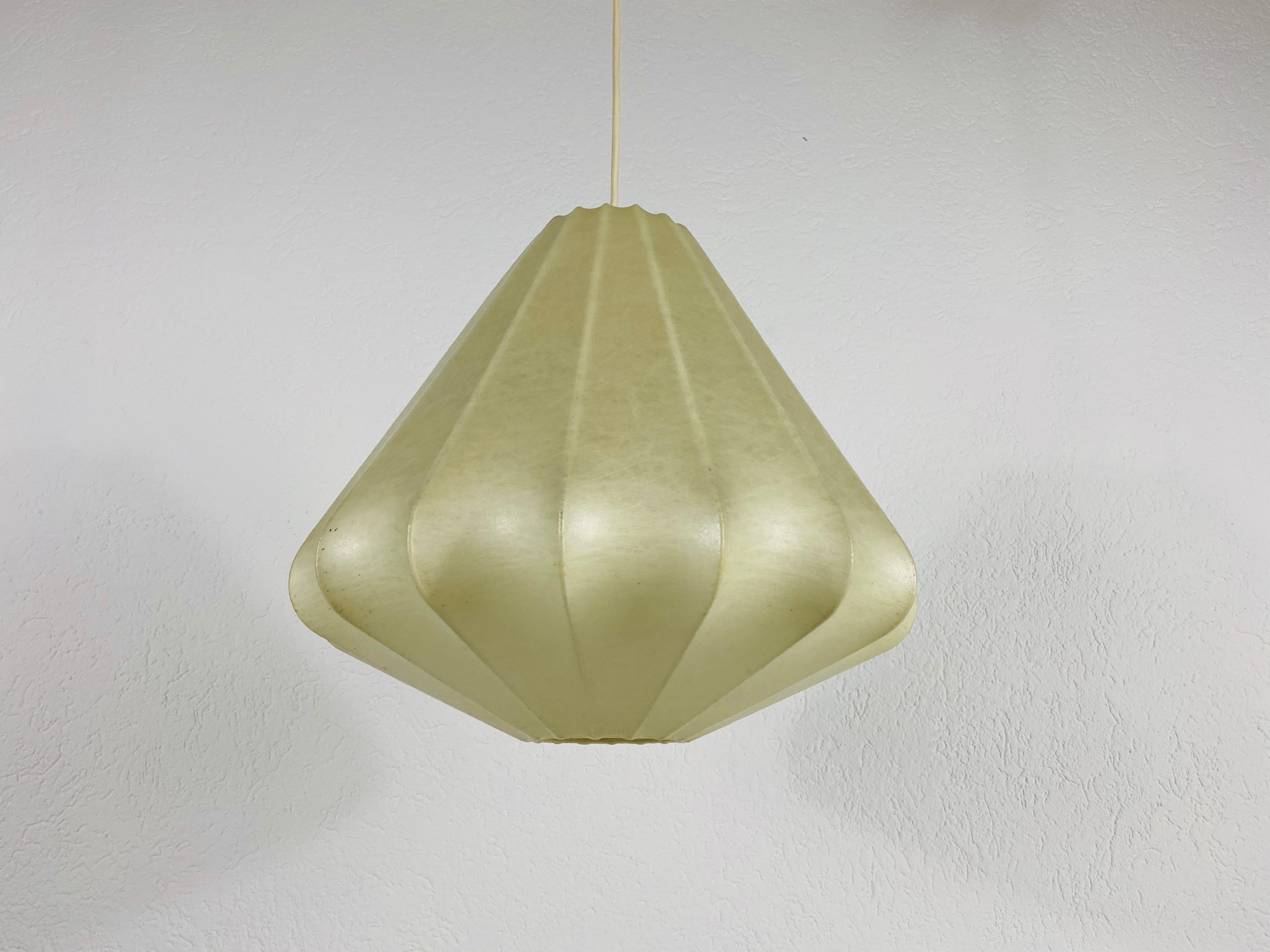 A cocoon pendant lamp made in Italy in the 1960s. The hanging lamp has been designed by Achille Castiglioni. The lamp shade is of original resin and has a losange shape.

Measures: Height 31-80 cm 
Diameter 34 cm

The light requires one E27