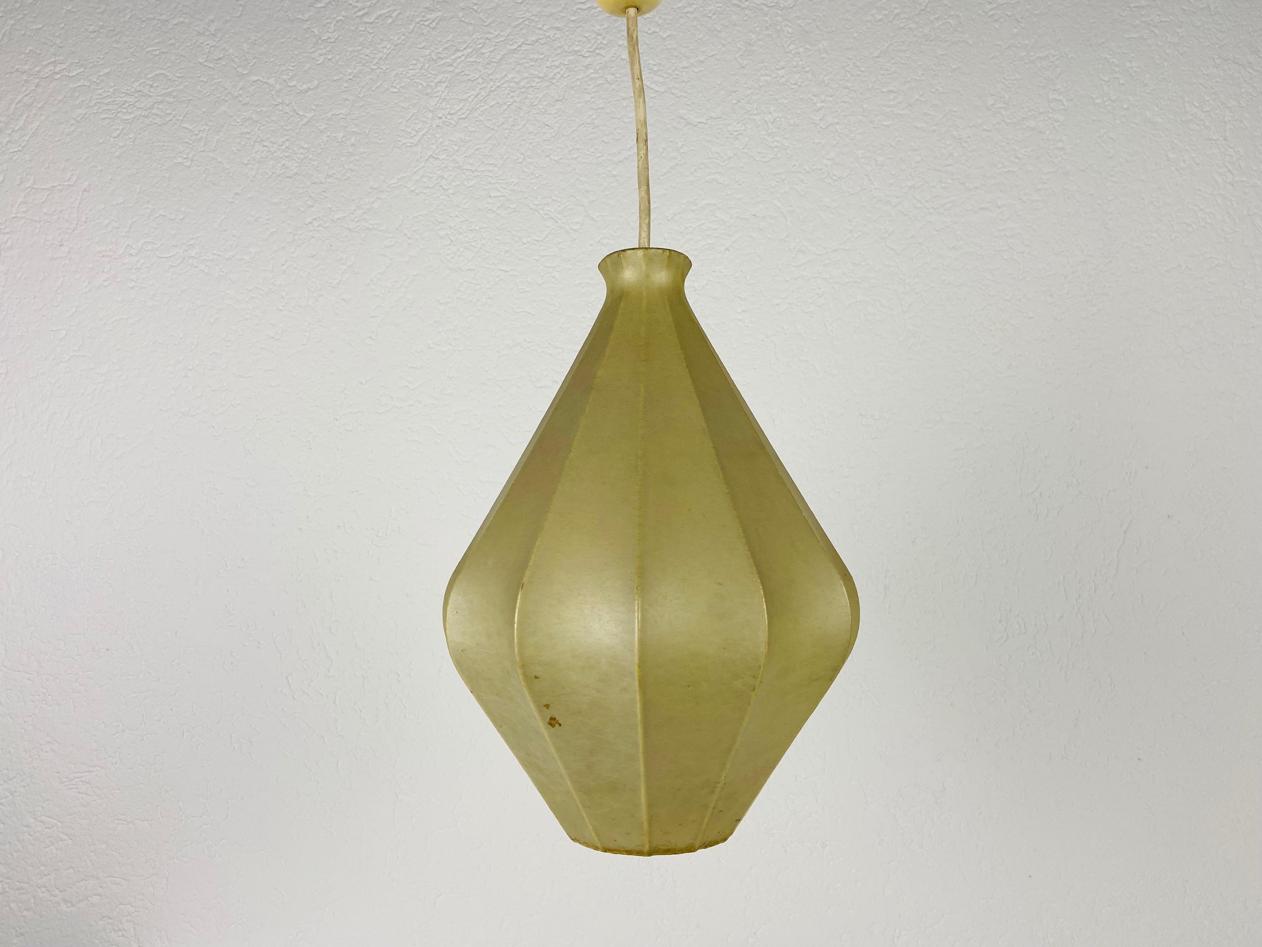 A cocoon pendant lamp made in Italy in the 1960s. The hanging lamp has been designed in the style of Achille Castiglioni. The lamp shade is of original resin and has a losange shape.

Measures: Height 32-55 cm 
Diameter 25 cm

The light