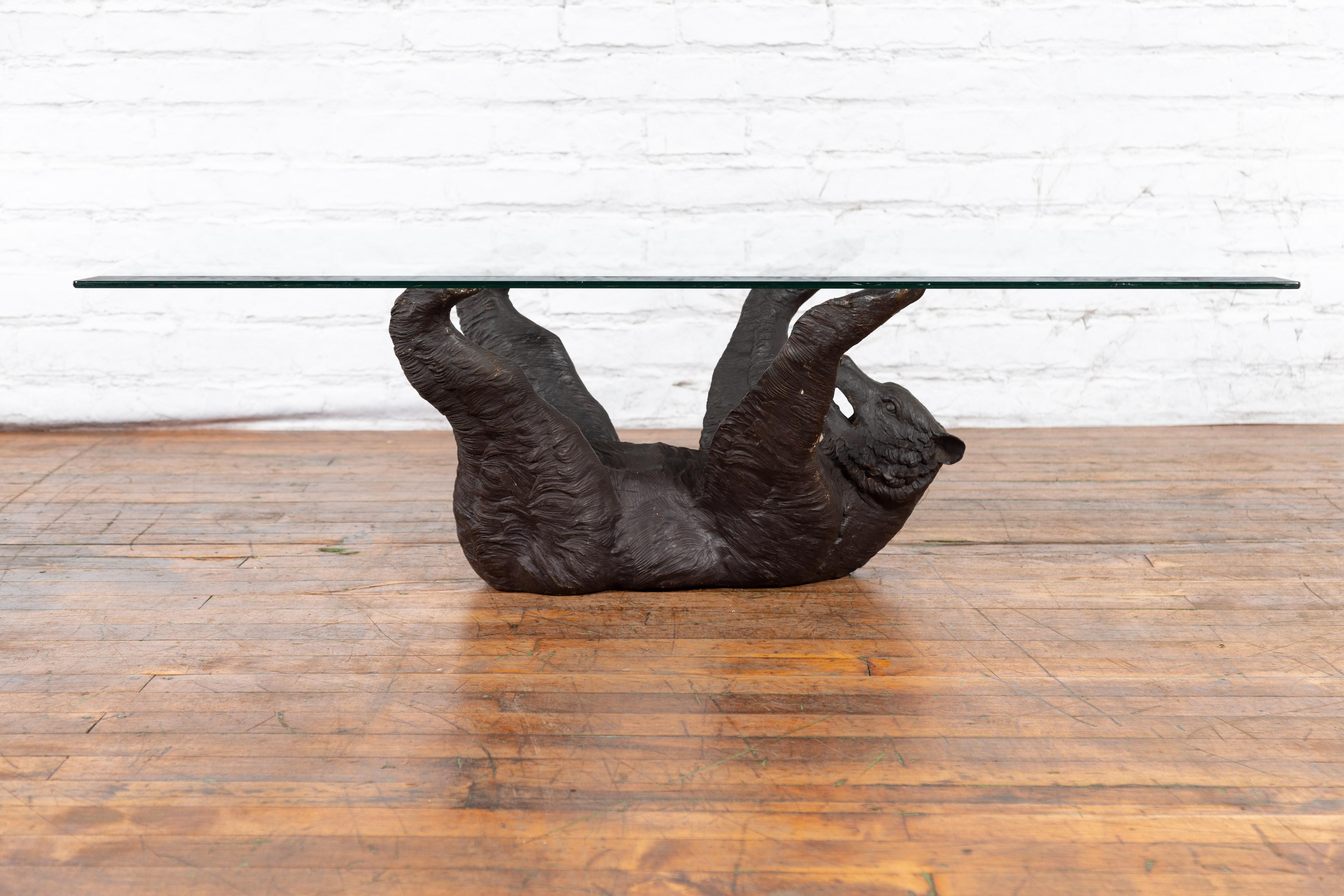 A contemporary lost wax cast bronze coffee table base depicting a bear laying on his back, with dark patina. Created with the traditional technique of the lost-wax (à la cire perdue) which allows for great precision and finesse in the details, this