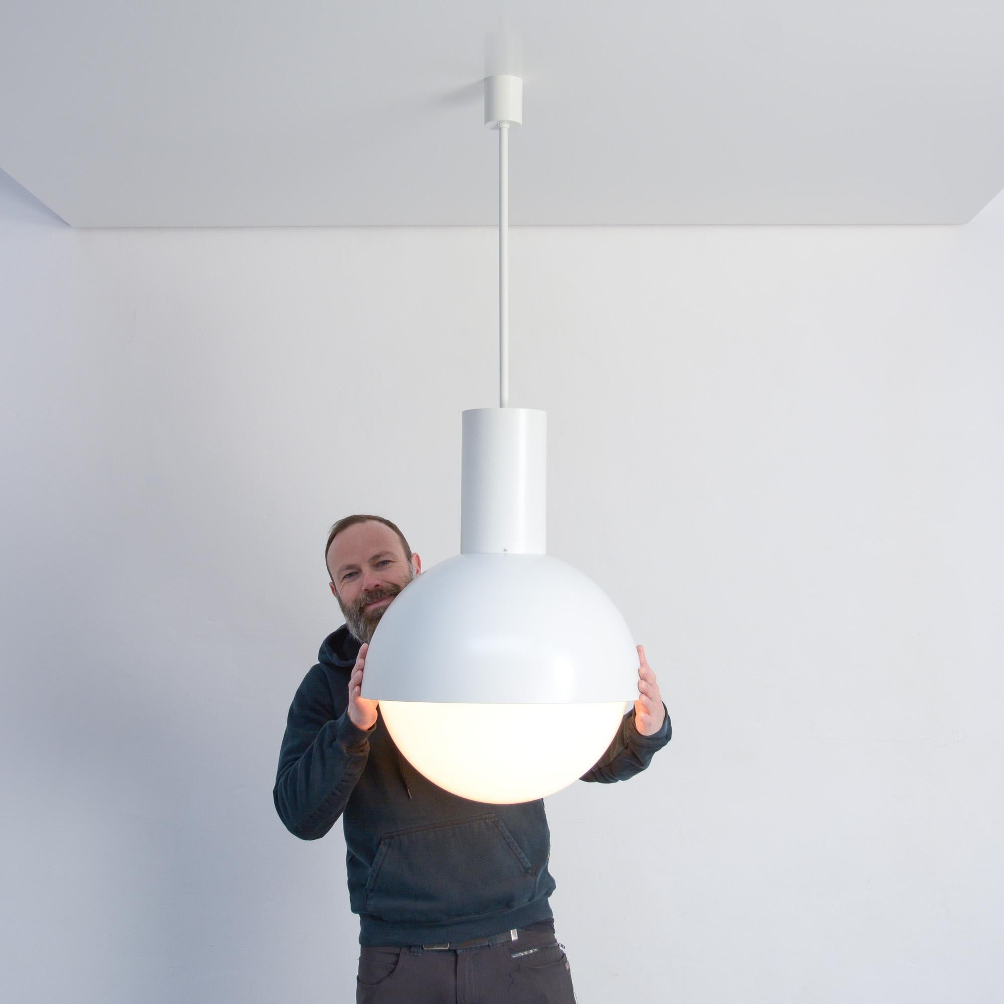 These white pendant lamps of the 1970s were manufactured by BEGA and Glashütte Limburg.
The white lacquered metal base (BEGA) holds the large opaline glass ball (Limburg).
Those lamps were once illuminating a church.
The effect of using different