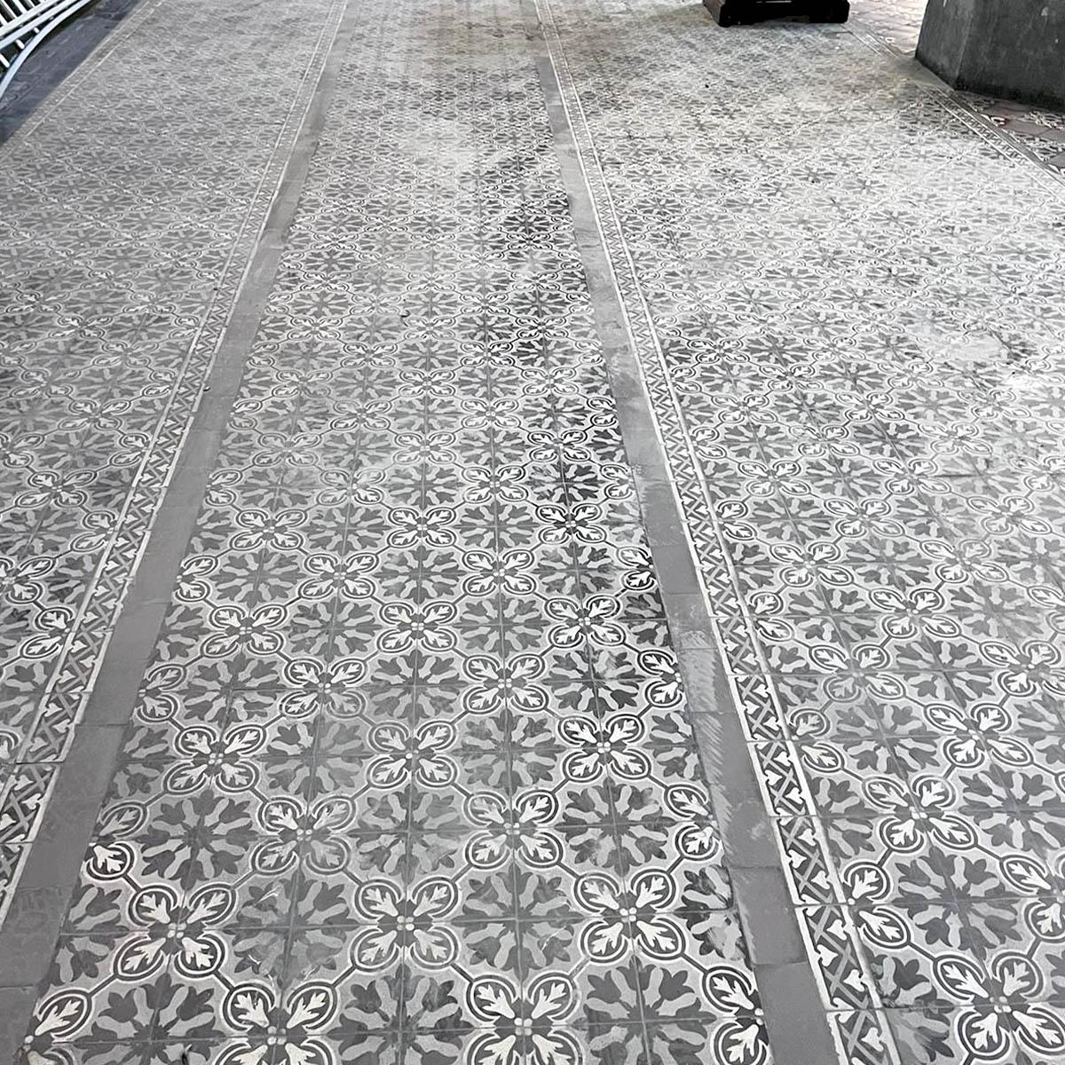 Exceptional lot of approximately 500 square meters of antique cement tiles featuring a richly detailed floral and geometric motif in shades of gray, black, and ivory. These tiles form a stunning symmetrical pattern with a central medallion and