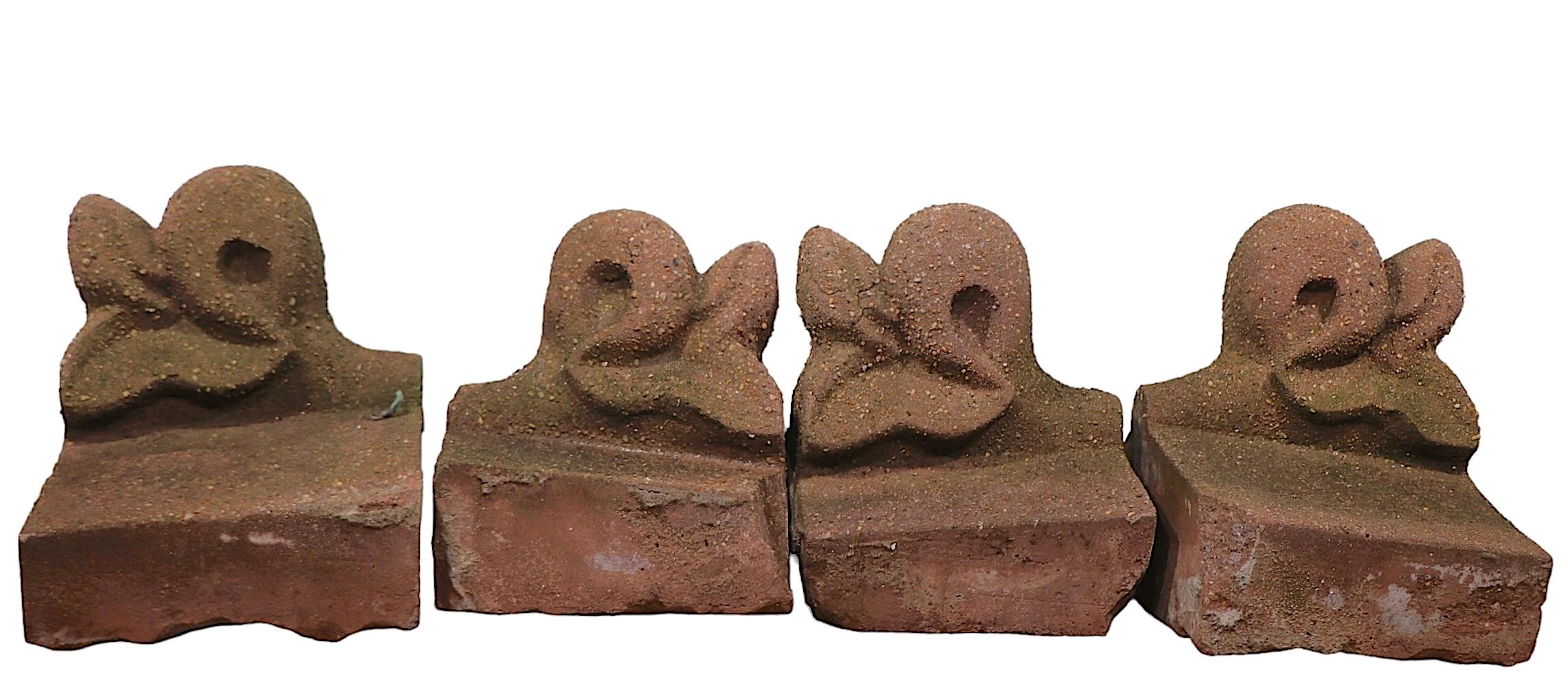 Grupo de cuatro fragmentos de edificio de arenisca, cada uno con una base en forma de bloque con crestas orgánicas onduladas. Probablemente procedentes de una casa de piedra rojiza de principios de siglo, estos bloques recuperados serán perfectos