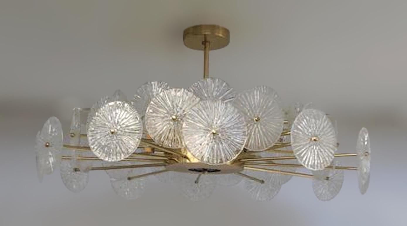 Italian chandelier with clear textured Murano glass discs mounted on lacquered polished brass finish frame, designed by Fabio Bergomi for Fabio Ltd / Made in Italy
12 lights / G9 type / max 40W each
Measures: Diameter: 45 inches / Height: 29.5