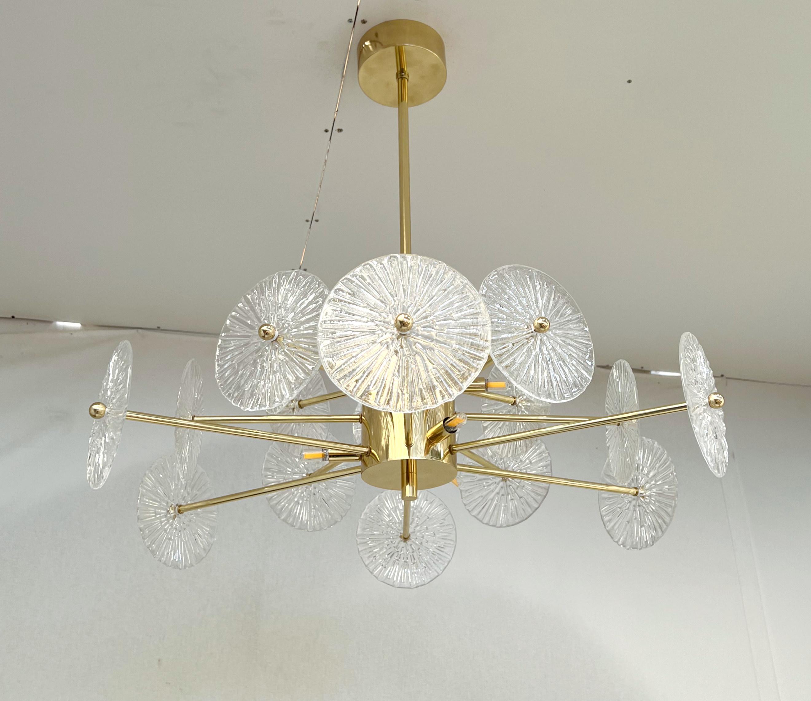 Italian chandelier with clear textured Murano glass discs mounted on lacquered polished brass finish frame, designed by Fabio Bergomi for Fabio Ltd / Made in Italy
6 lights / G9 type / max 40W each.
Measures: diameter: 29.5 inches / height: 27.5