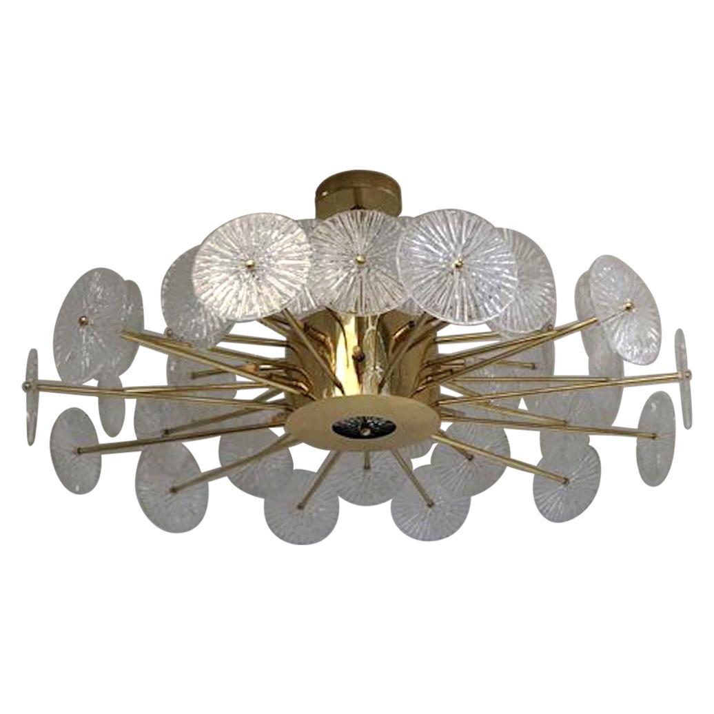 Italian chandelier with clear textured Murano glass discs mounted on lacquered polished brass finish frame, designed by Fabio Bergomi for Fabio Ltd / Made in Italy
12 lights / G9 type / max 40W each
Measures: Diameter: 45 inches / Height: 29.5