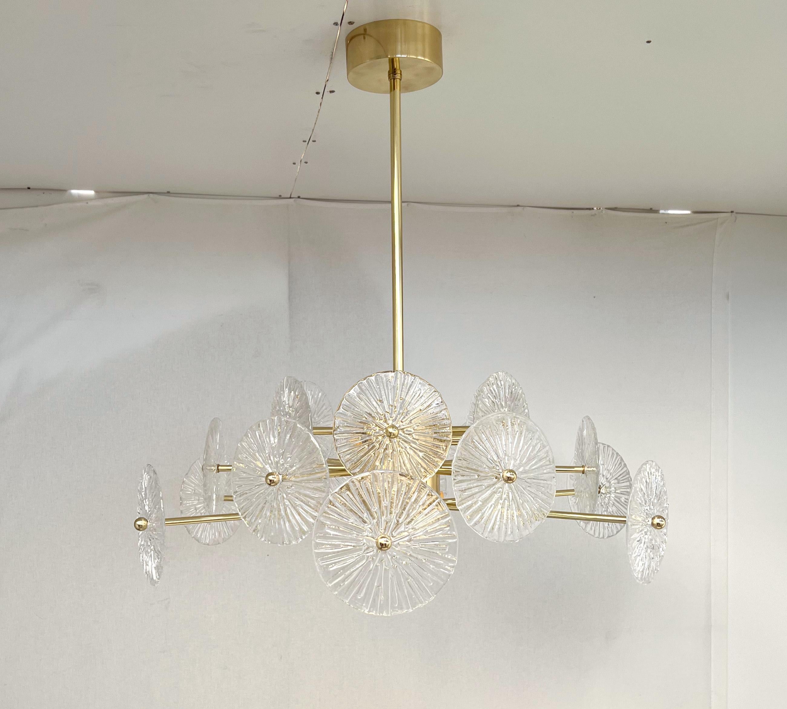 Italian chandelier with clear textured Murano glass discs mounted on lacquered polished brass finish frame, designed by Fabio Bergomi for Fabio Ltd / Made in Italy
6 lights / G9 type / max 40W each
Measures: Diameter: 29.5 inches / Height: 27.5