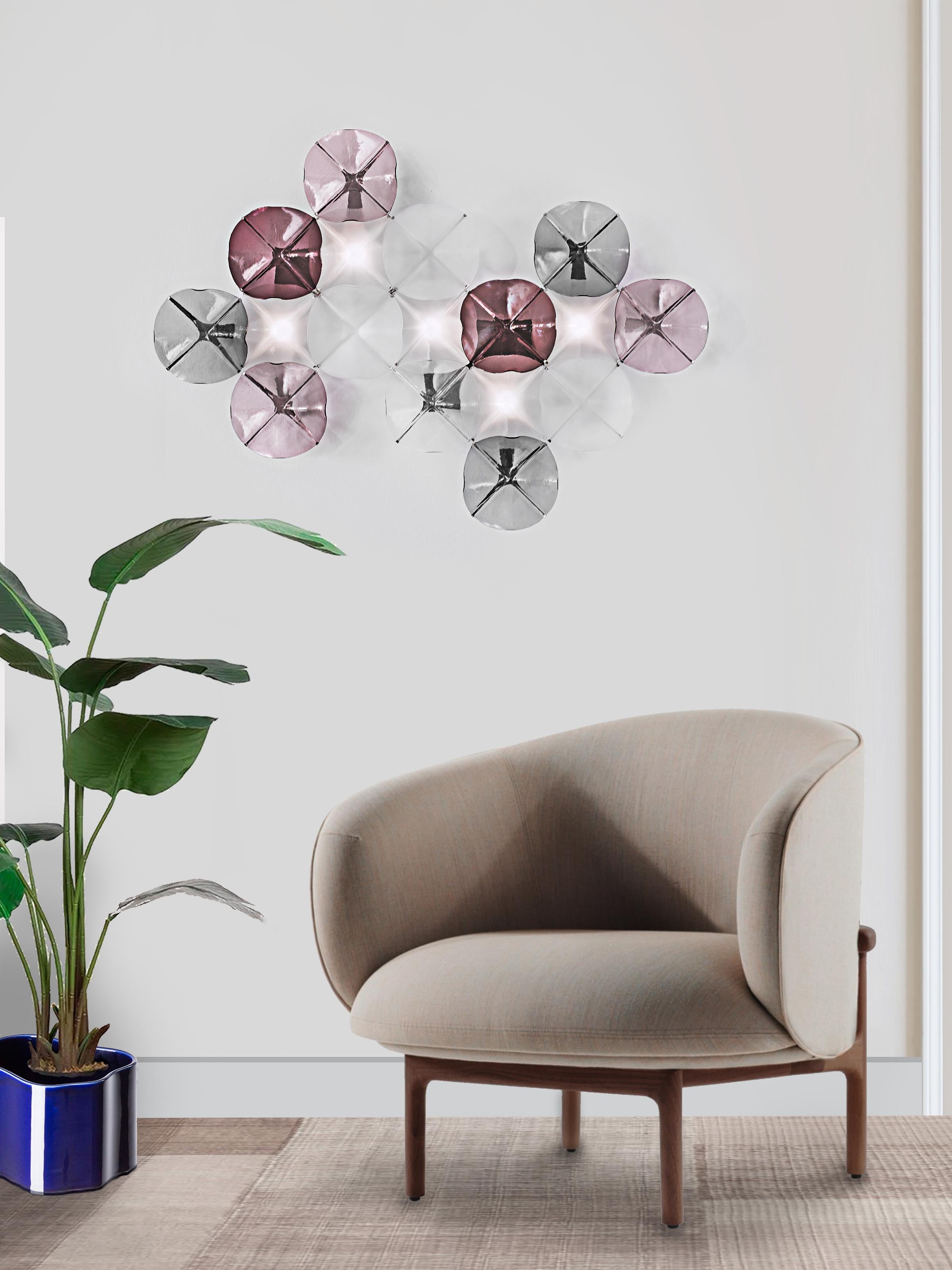 The LOTO wall light is a composition of 17 flower-shaped glass pieces assembled following an orthogonal pattern. The elegance of its
shape makes this system ideal for the most sophisticated spaces.
The colored artisan glass pieces are mounted on a